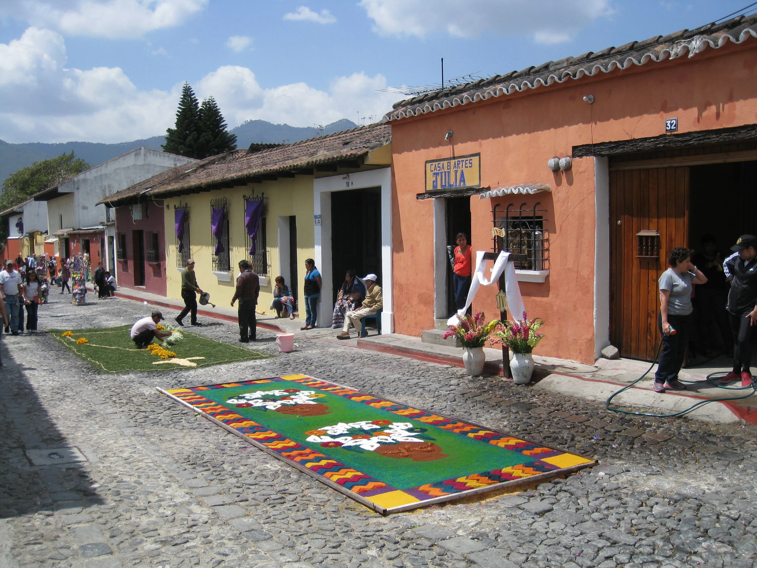  Antigua--Calle 3--Putting Alfombras (Rugs) in the street in honor of the procession. These are designed and made of colored sawdust, flowers and other plants, by the neighbors. 