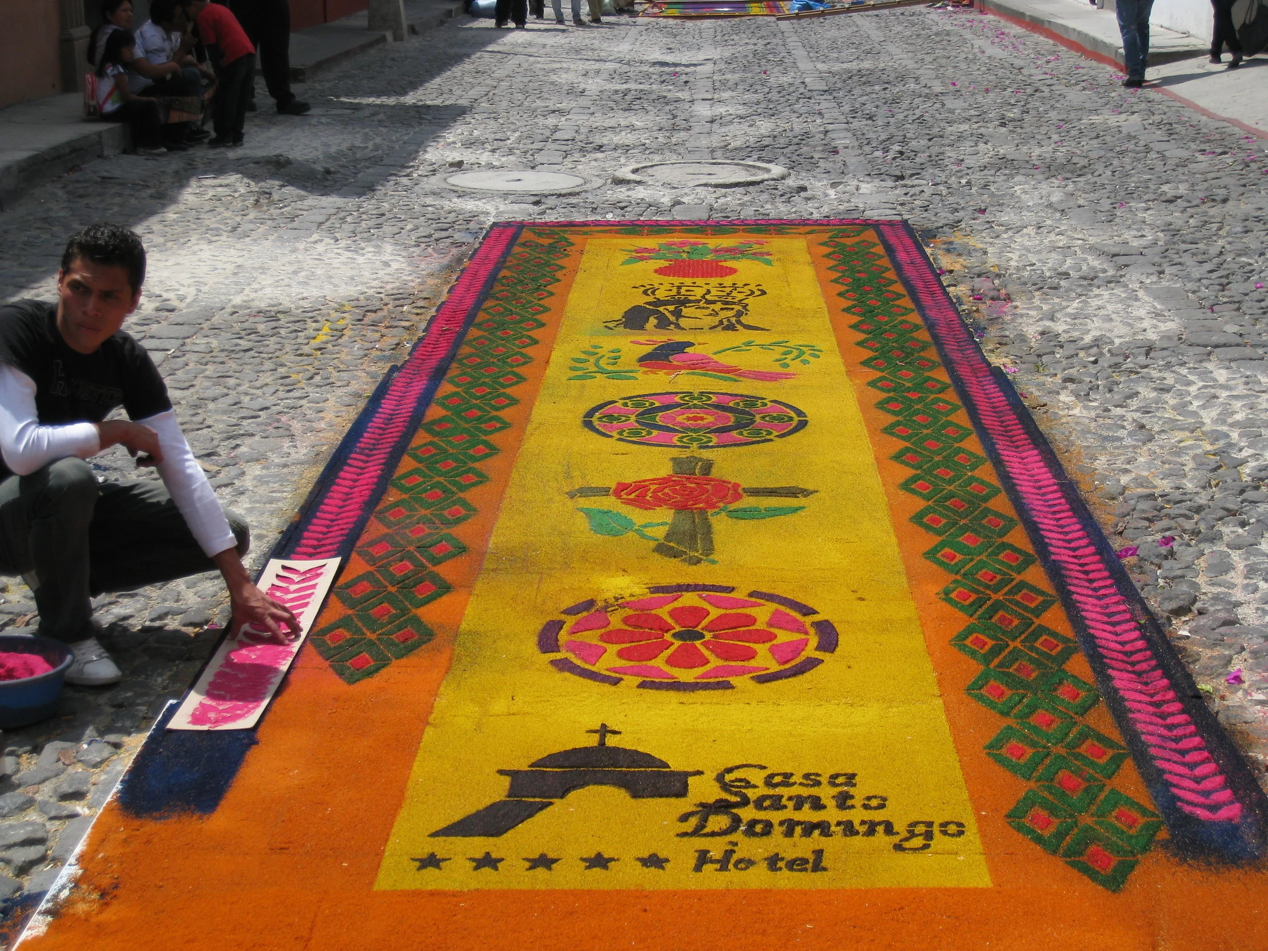  Antigua--Calle 3--Putting Alfombras (Rugs) in the street in honor of the procession. These are designed and made of colored sawdust, flowers and other plants, by the neighbors. This one was done by a hotel group 