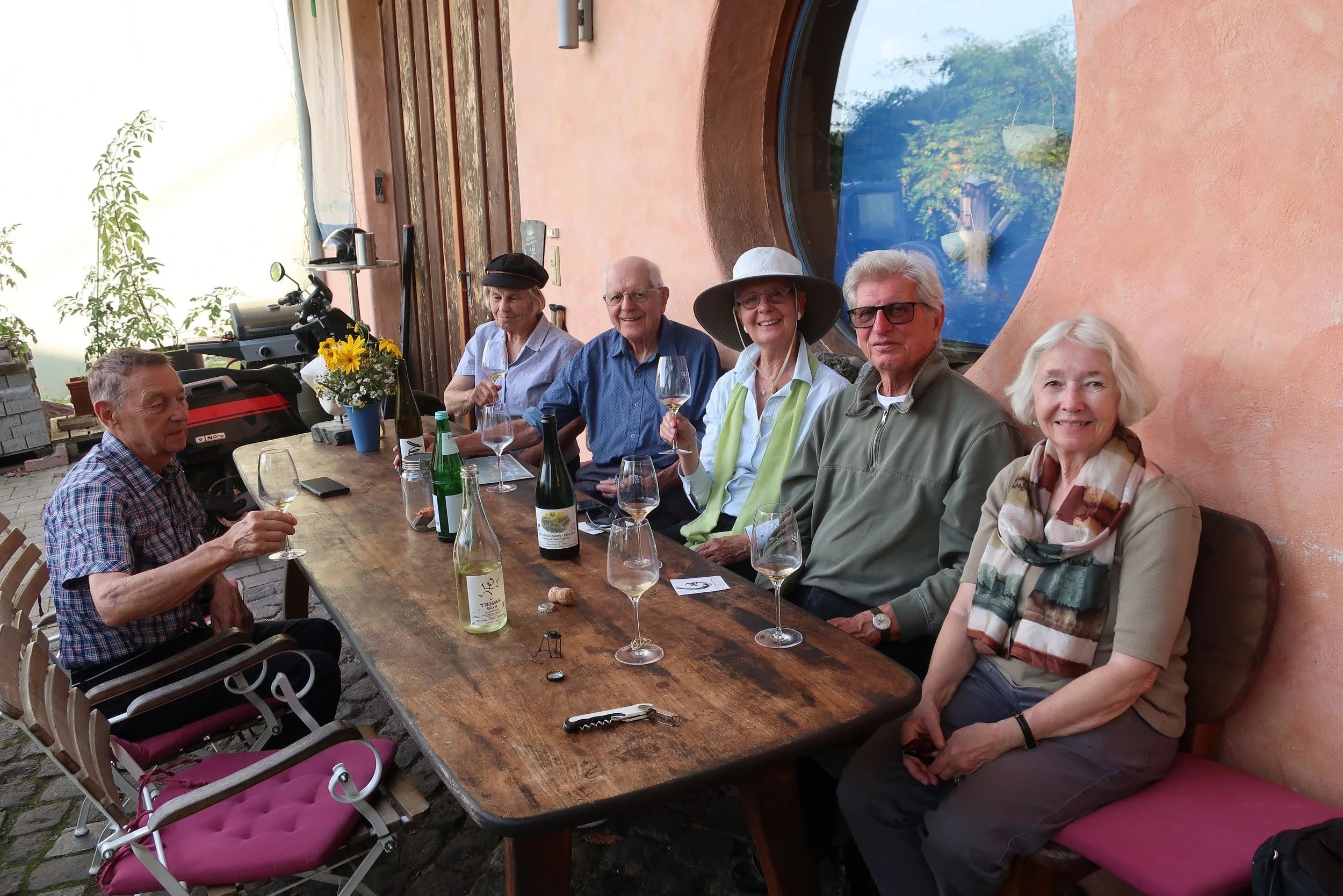  Germany 2023--Kindel 50th Anniversary Trip--Kindel--Harald Grieser, Judy and Paul Kindel, Christin Grieser-Kindel and Karl and Carrol Kindel tasting wine and being photographed by Vintner and owner Rudolf Trossen with his wines in Kindel 