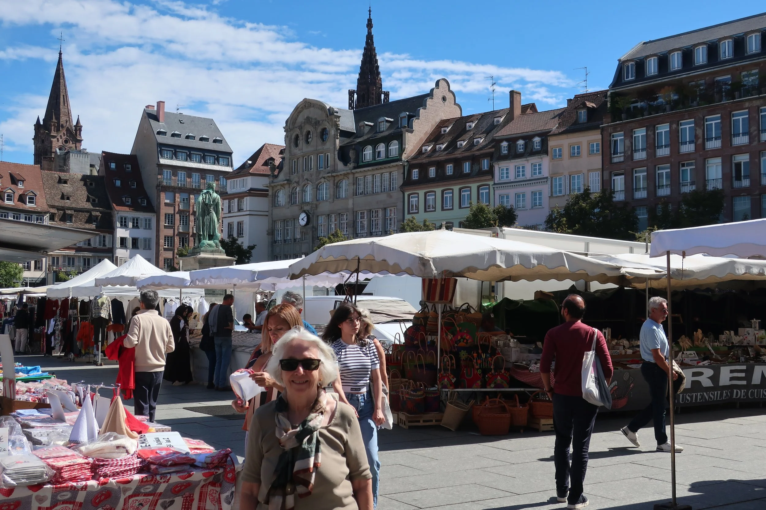  France--Strasbourg 2025--The Place Kleber in the old town with a clothing market and the Notre Dame Cathedral, with Carrol Benner Kindel 