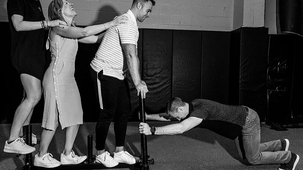 Dr+Josh+Grahlman+pushes+Team+Clutch+Physical+Therapy+on+sled.jpg