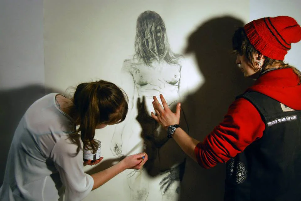 Lion's Main member Sofya Belinskaya performs a live shadow drawing in the gallery.