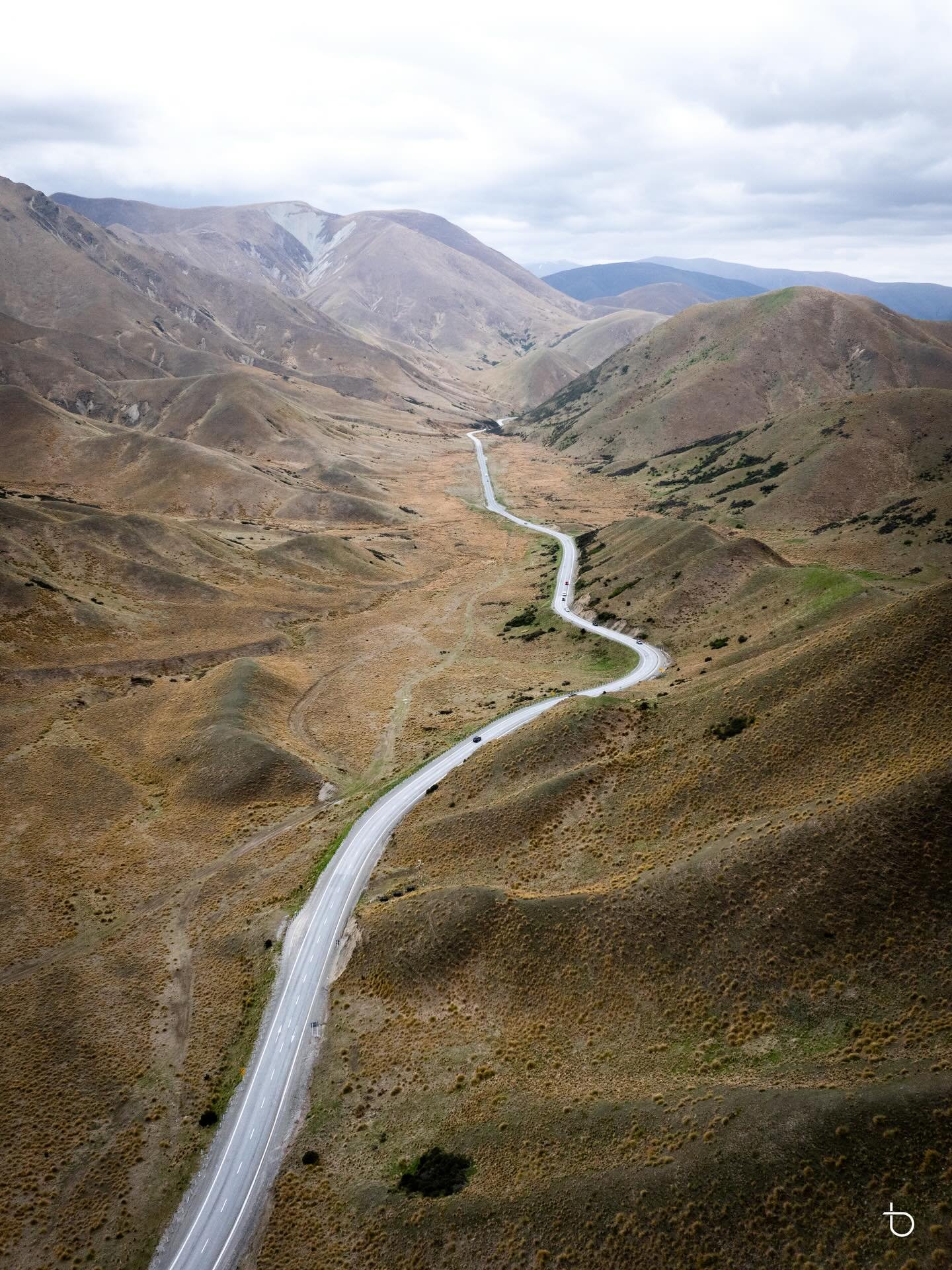 Endless curves cutting through the rugged hills of Lindis Pass. This aerial view shows just how dramatic and untouched this landscape feels &mdash; a winding road threading its way through one of New Zealand&rsquo;s most breathtaking high-country reg