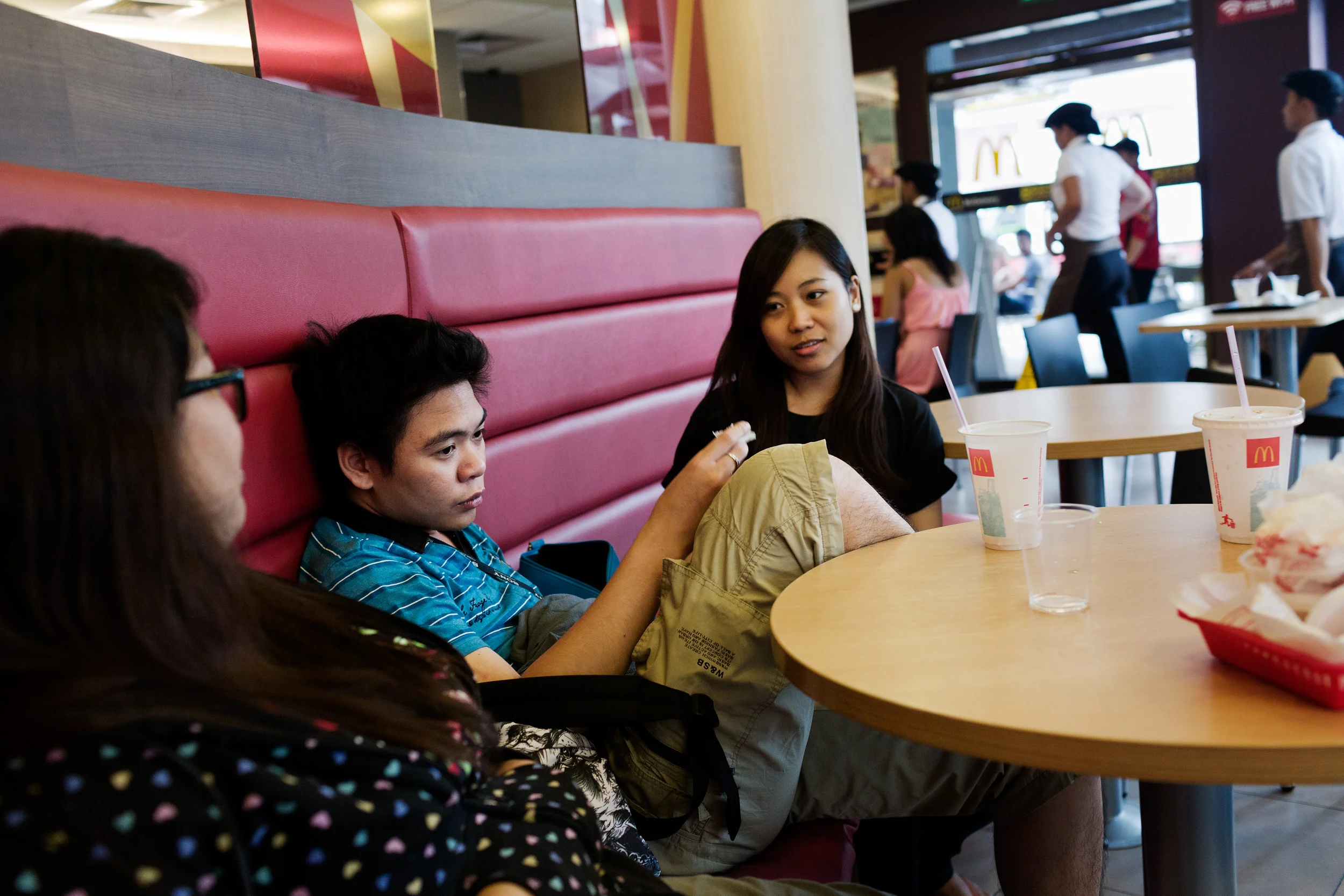  Call centre workers Athena, Ron and Mina eat McDonalds together in Eastwood City, Philippines, after working the night shift.&nbsp;  Ron explains, “They’re so far away from us they can’t touch us, they can just complain and complain. &nbsp;They talk
