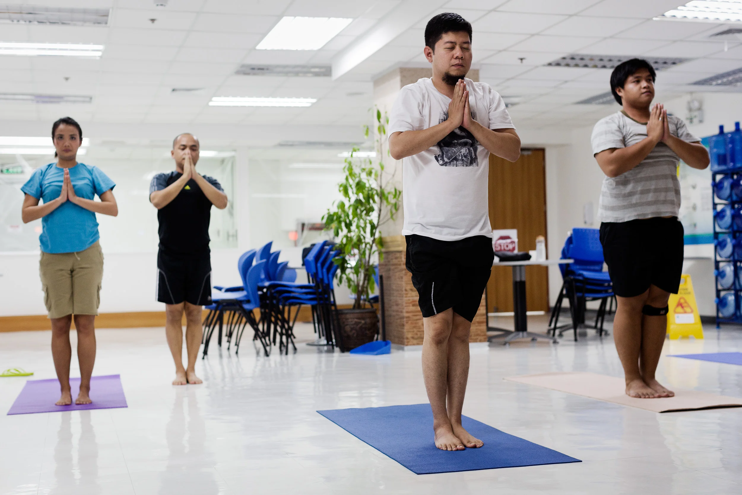  Call centre workers of Acquire Asia Pacific in Eastwood City, Philippines, take a yoga class in the office, instructed by Mallet Gamez, an employee who brought his his extra curricular interest to share with fellow employees for relaxation. 
