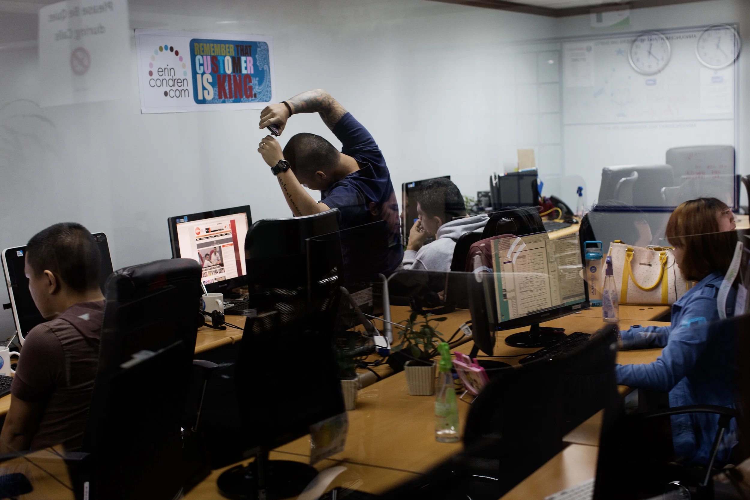  A call centre worker stretches as he works early into the morning at Staff Virtual in Makati City, Philippines. 