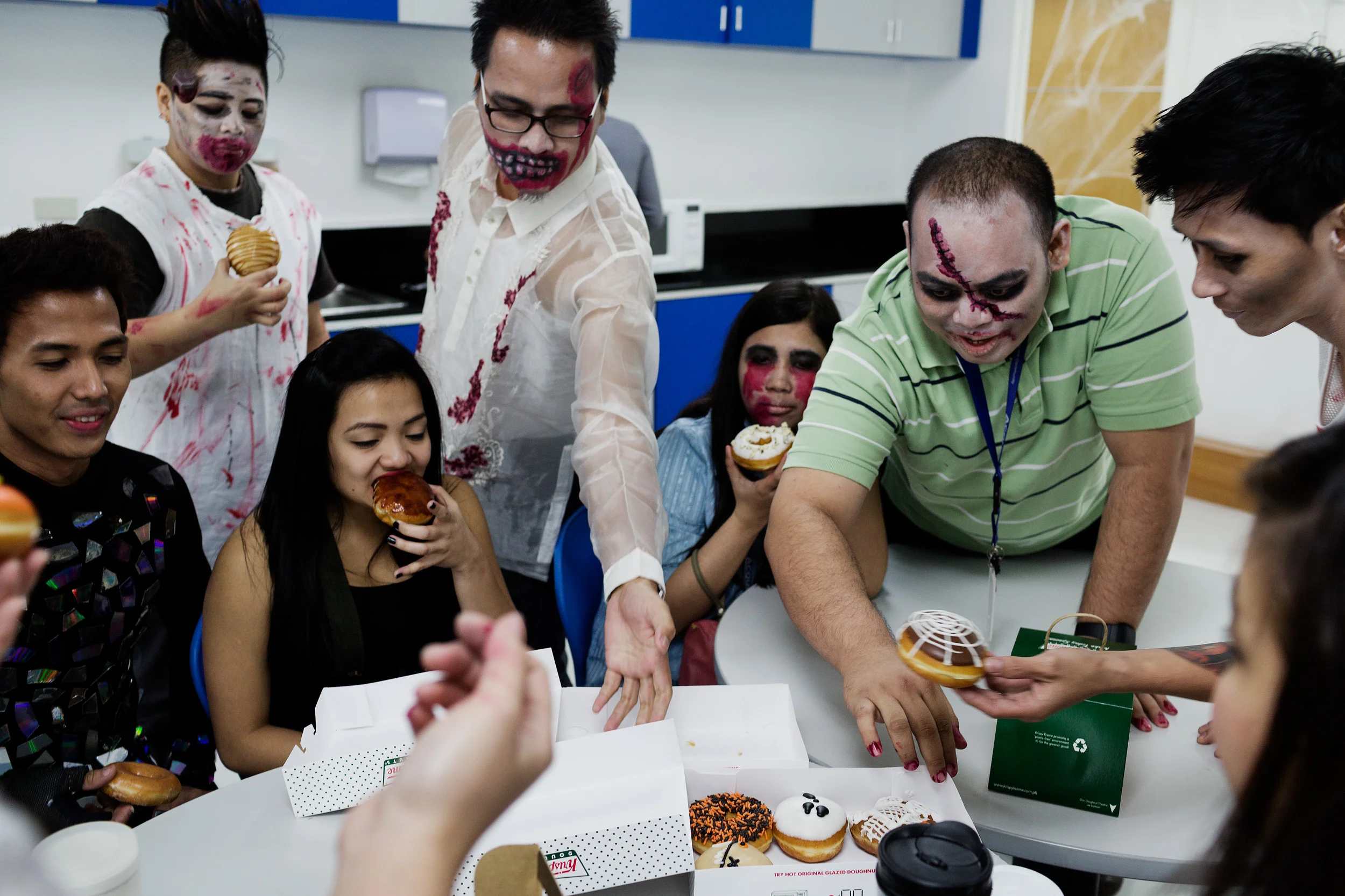  Employees of Acquire Asia Pacific, an outsourcing company in Eastwood City, Philippines, celebrate Halloween and eat Krispy Kreme doughnuts on their lunch break. 