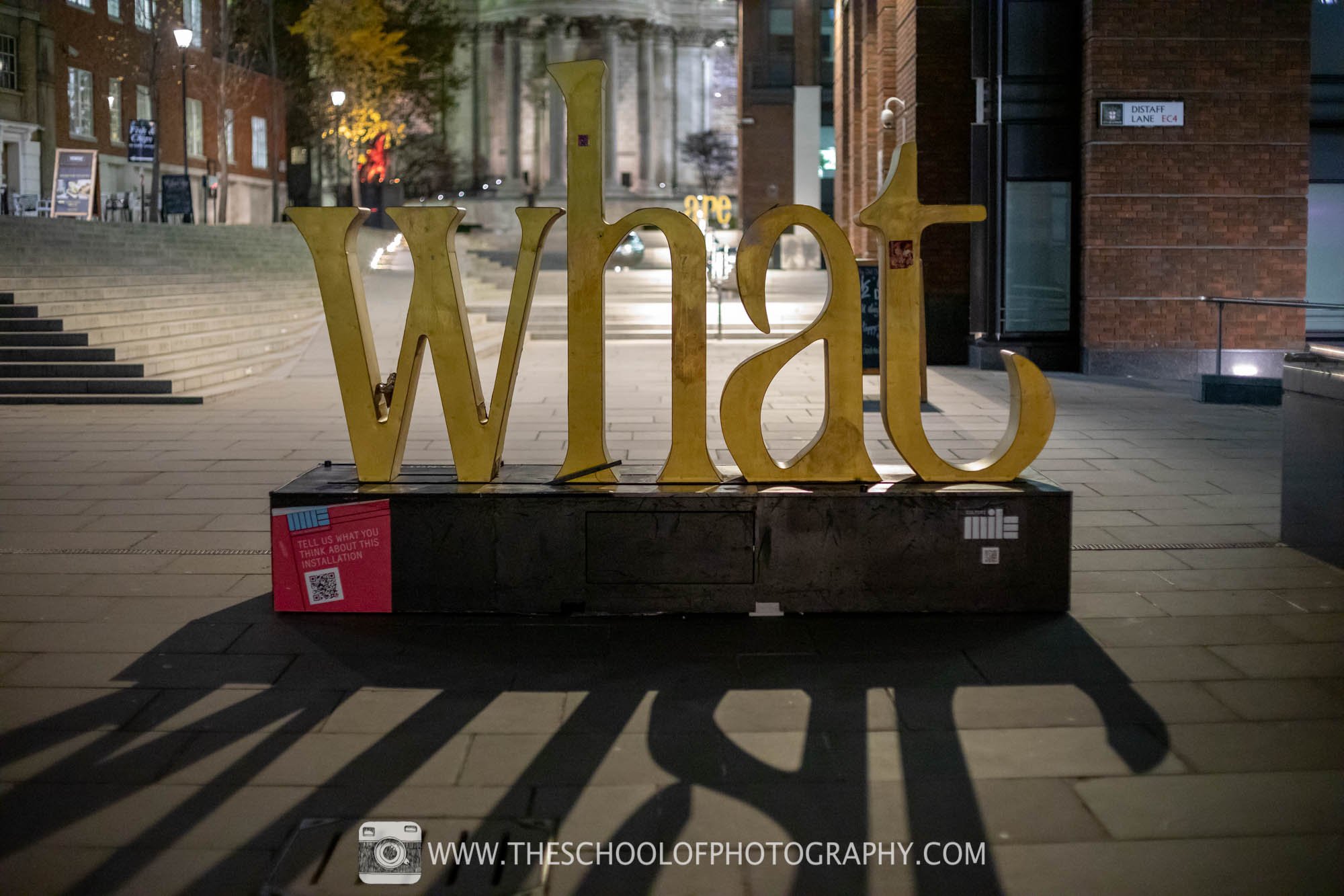 A sign spelling out the word 'What' using full frame camera
