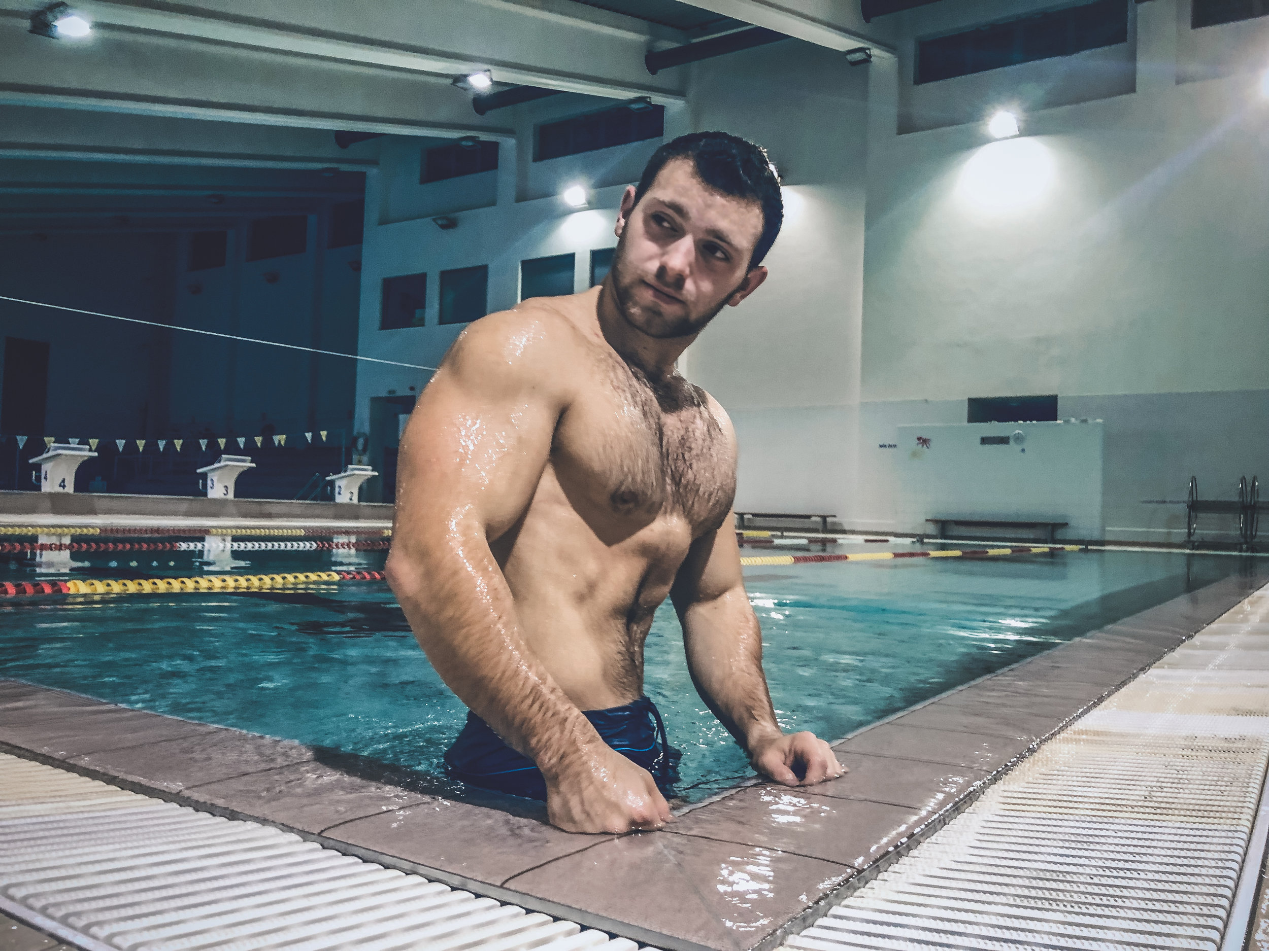 giant man flexing his big muscles in pool