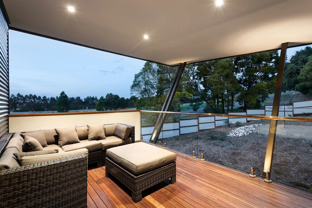 Covered outdoor entertaining area of this luxury home offering landscape views