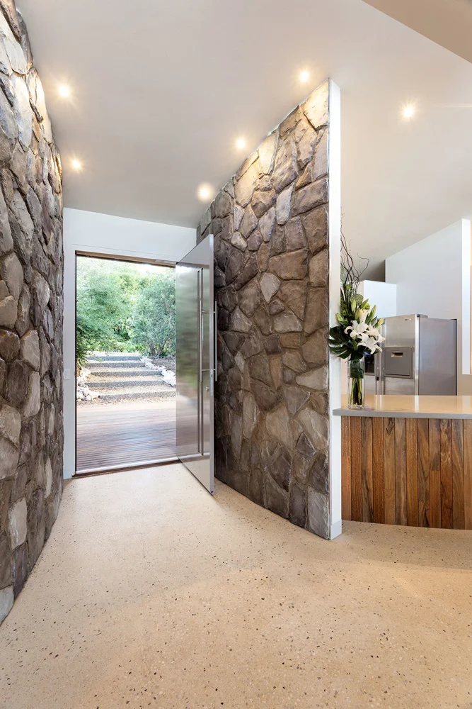 Stone entryway facade with recessed lighting above