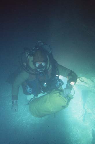  Rob Parker transporting gear through Sump 5 (140 meters long). Inside the duffel were food supplies, carbide, and climbing gear needed at Camp 2. [photo �1984 Bill Stone] 