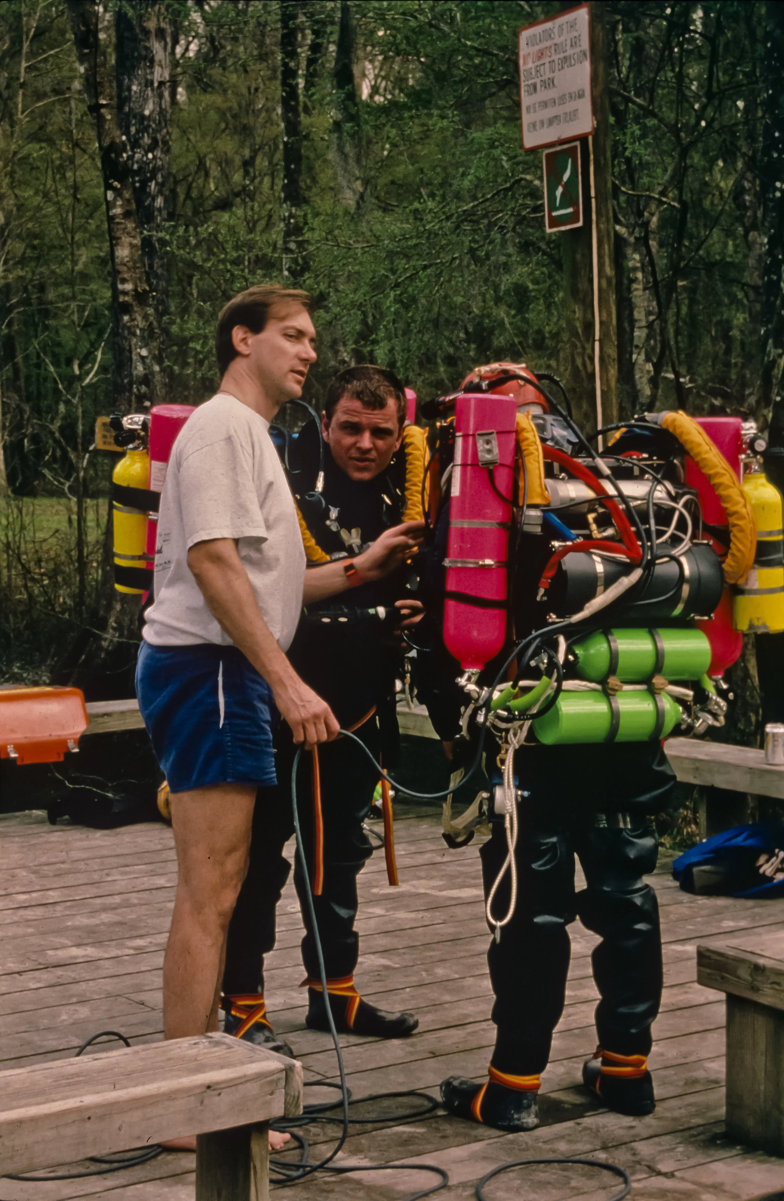 Noel Sloan discusses a dive plan with Ian Rolland and Kenny Broad (back to camera) on the deck at Devil's Eye spring during rehearsal dives for the 1994 San Agustin expedition. Photo by U. S. Deep Caving Team/Bill Stone.