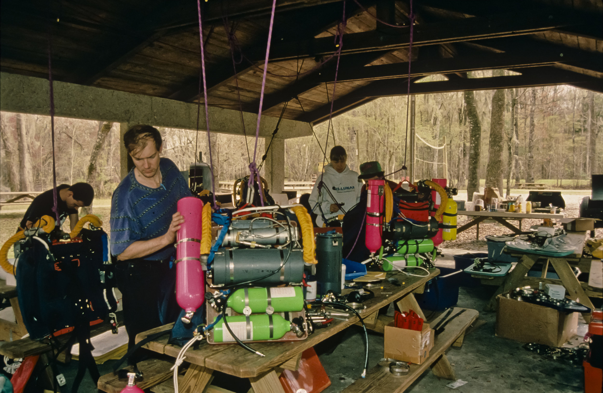  Ian Rolland, Noel Sloan, and Barbara am Ende (left to right) assemble Mk4 rebreathers at the Ginnie Springs pavilion near Devil's Eye spring. Photo by U.S. Deep Caving Team/Bill Stone. 