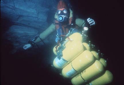  The problems with open circuit scuba: Rob Parker transporting a "sled" of 8 composite tanks through Sump 3 at the Peña Colorada. Multiple sherpa trips carrying loads such as this were required to support pushes on more remote sumps. Seige logistics 
