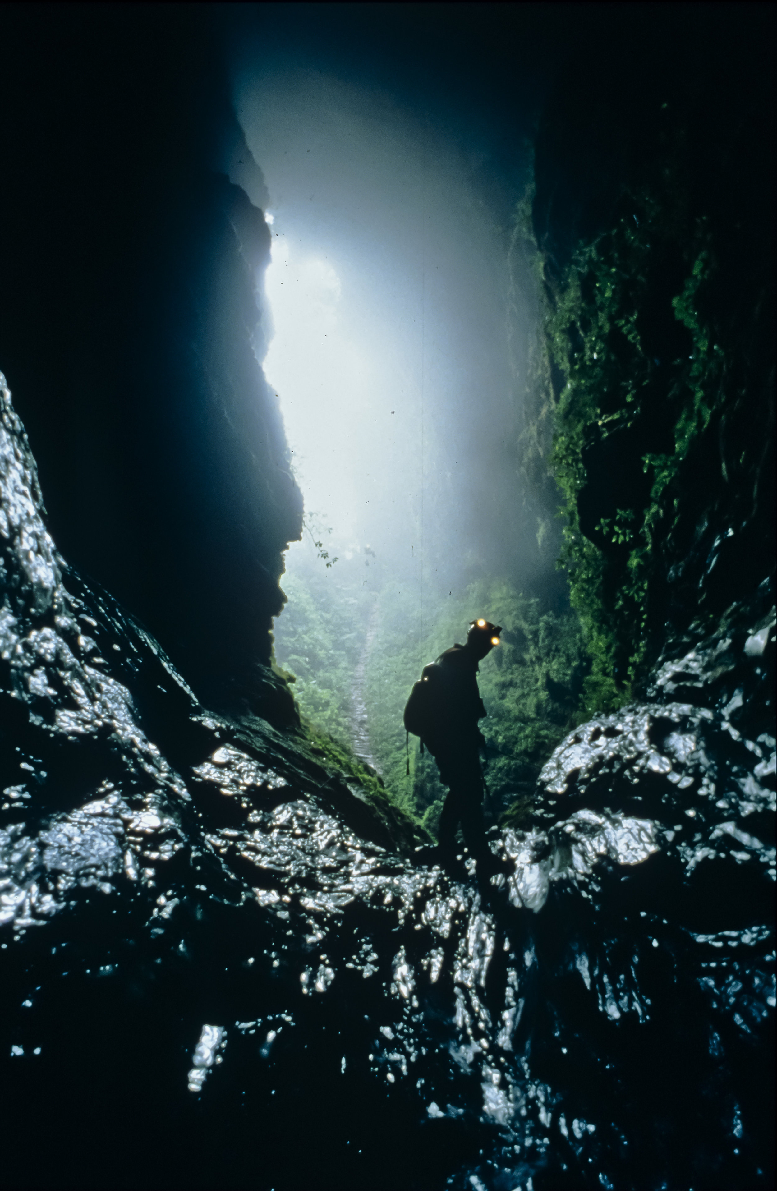  Steve Porter begins a descent of the 90m "slip and slide" drop, a steeply sloping, polished sluice way which is slickened by the spray from a small waterfall which drops in from a fissure in the roof 60m overhead.&nbsp;Photo by U. S. Deep Caving Tea