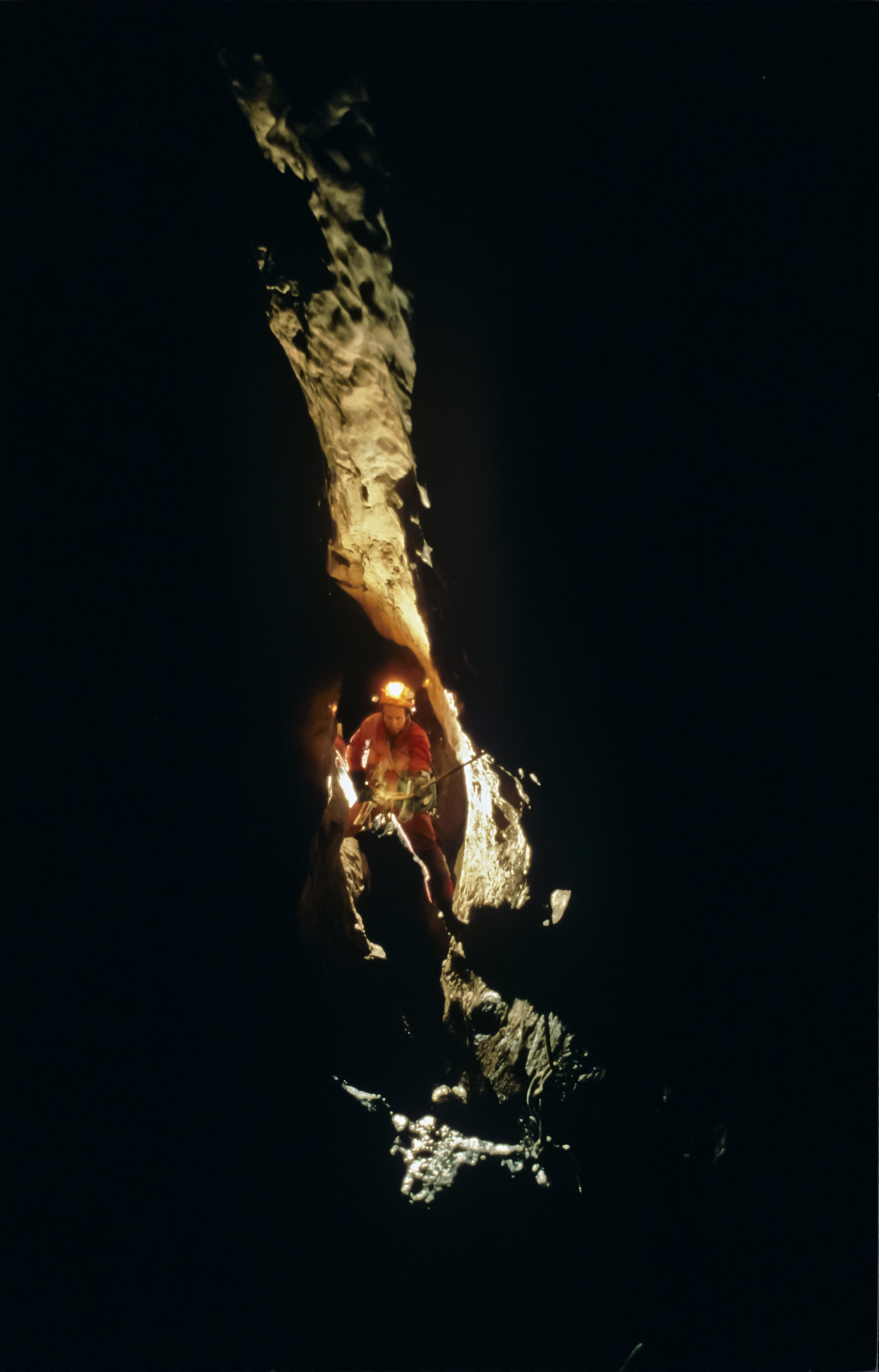  Edging out over the abyss, Steve Porter begins a descent of "The 100m Shaft", first in a series of deep pitches which descend more than 300m with very little horizontal offset. Photo by U. S. Deep Caving Team/Wes Skiles. 