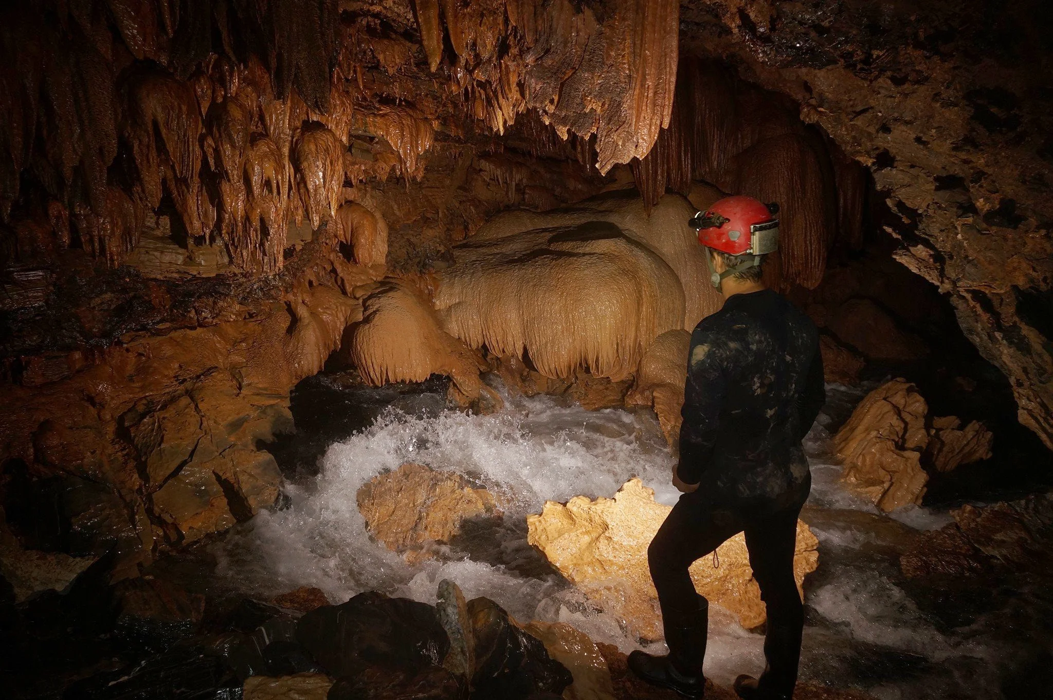 Andreas Klocker looking at the flowstone restriction at the most upstream end of the cave. Photo by Chris Jewell.