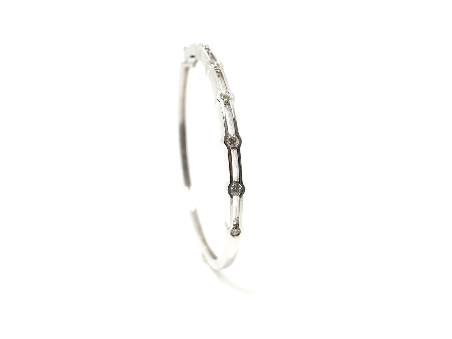Lovely quality 9ct white gold bangle, set with six brilliant cut diamonds in this unusual design. Approximately 0.5ct diamond weight total. With safety catch.
