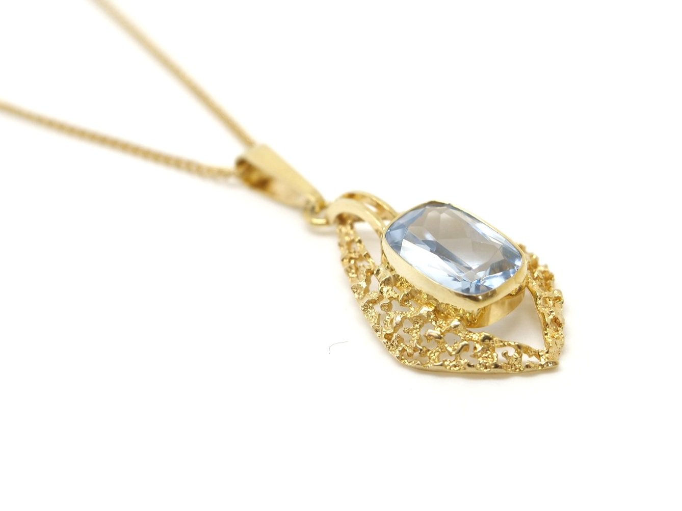 Lovely vintage 9ct gold blue topaz pendant and chain, set with a cushion cut blue topaz in a filigree gold design.
