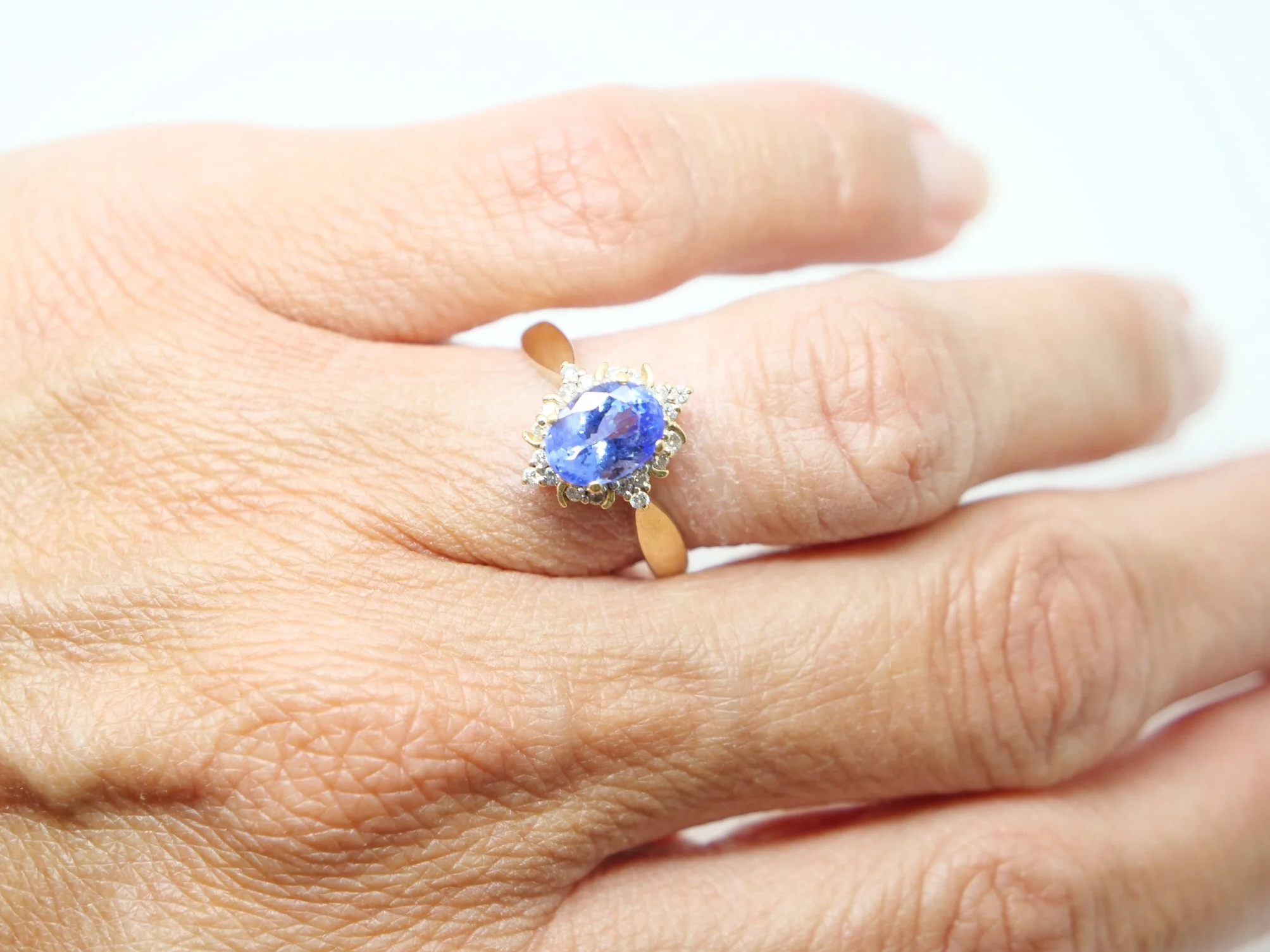 Very pretty 18ct gold tanzanite and diamond cocktail ring, set with a vibrant oval cut tanzanite and surrounded by brilliant cut diamonds.