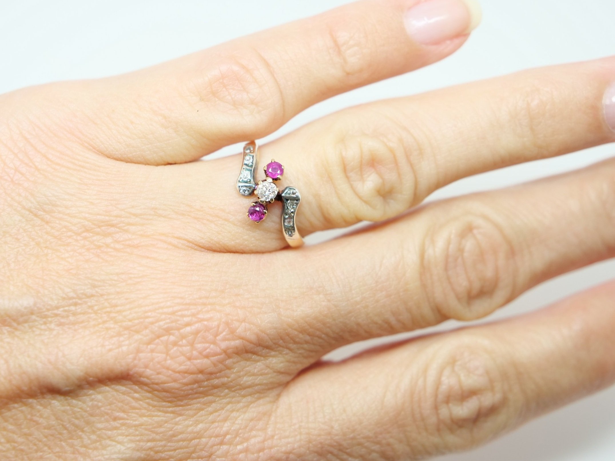 Stunning Art Deco 18ct gold ruby and diamond twist ring, set with a central old cut diamond, with a ruby to each side. Further diamonds set to each shoulder.