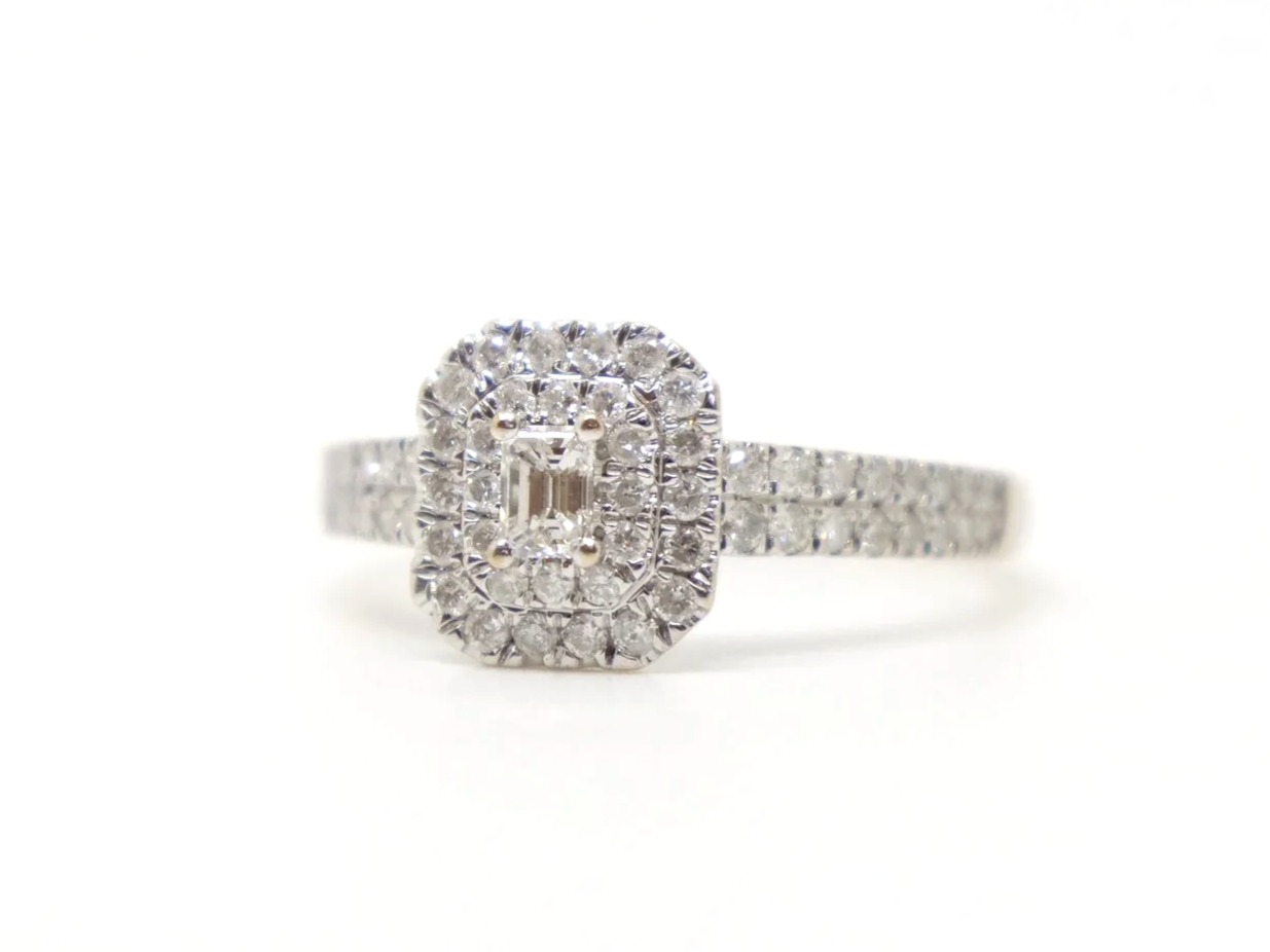 Very sparkly contemporary 18ct gold diamond cluster ring, set with a central emerald cut diamond and surrounded by further brilliant cut diamonds.