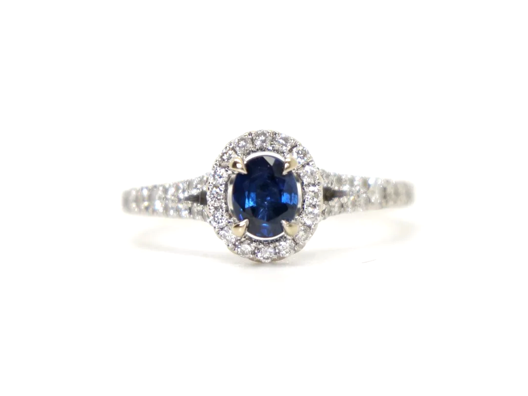 Very pretty 18ct gold sapphire and diamond ring, set with an oval cut sapphire and surrounded by diamonds. With split shank diamond shoulders.