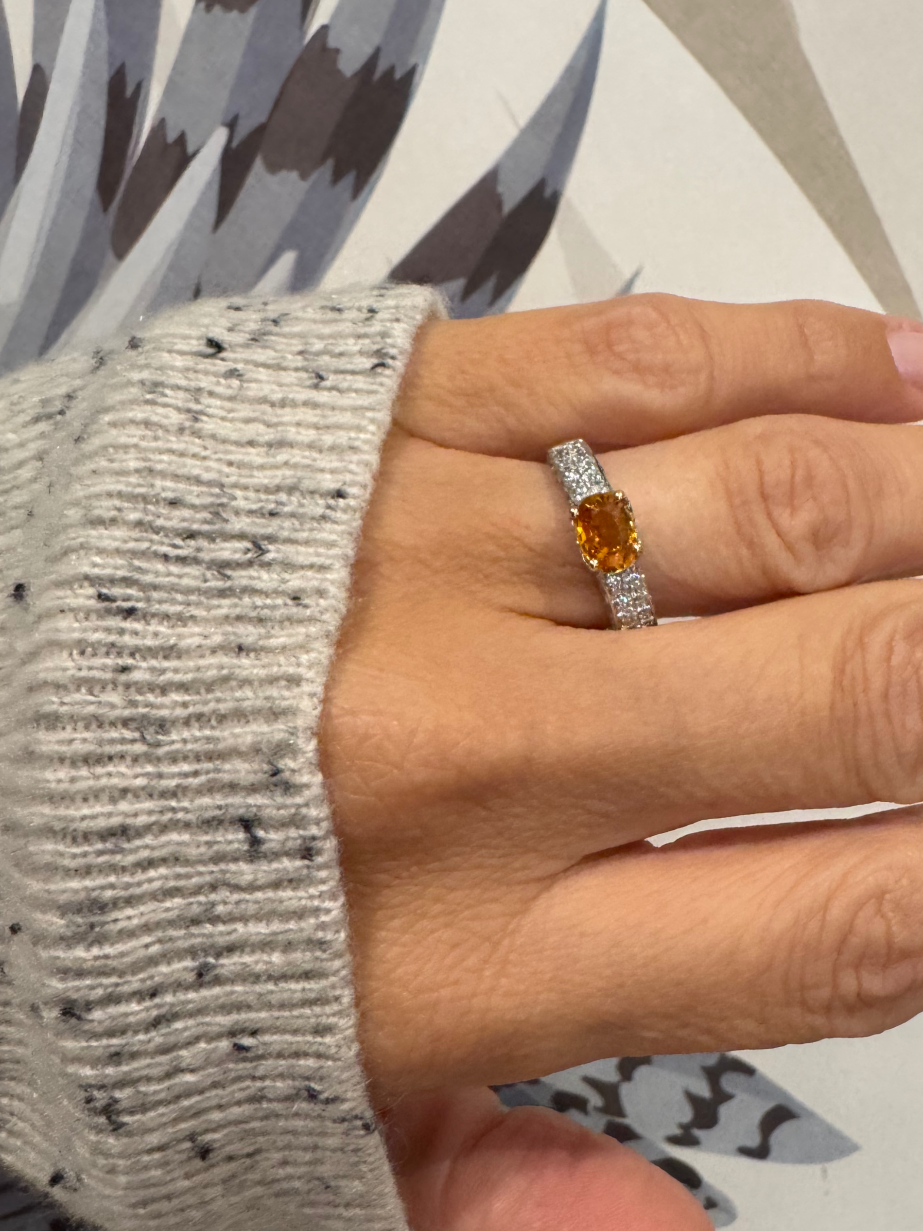 Beautiful 18ct gold orange sapphire and diamond ring, with a vibrant orange sapphire in an east-west setting, with pave style diamonds to each shoulder.