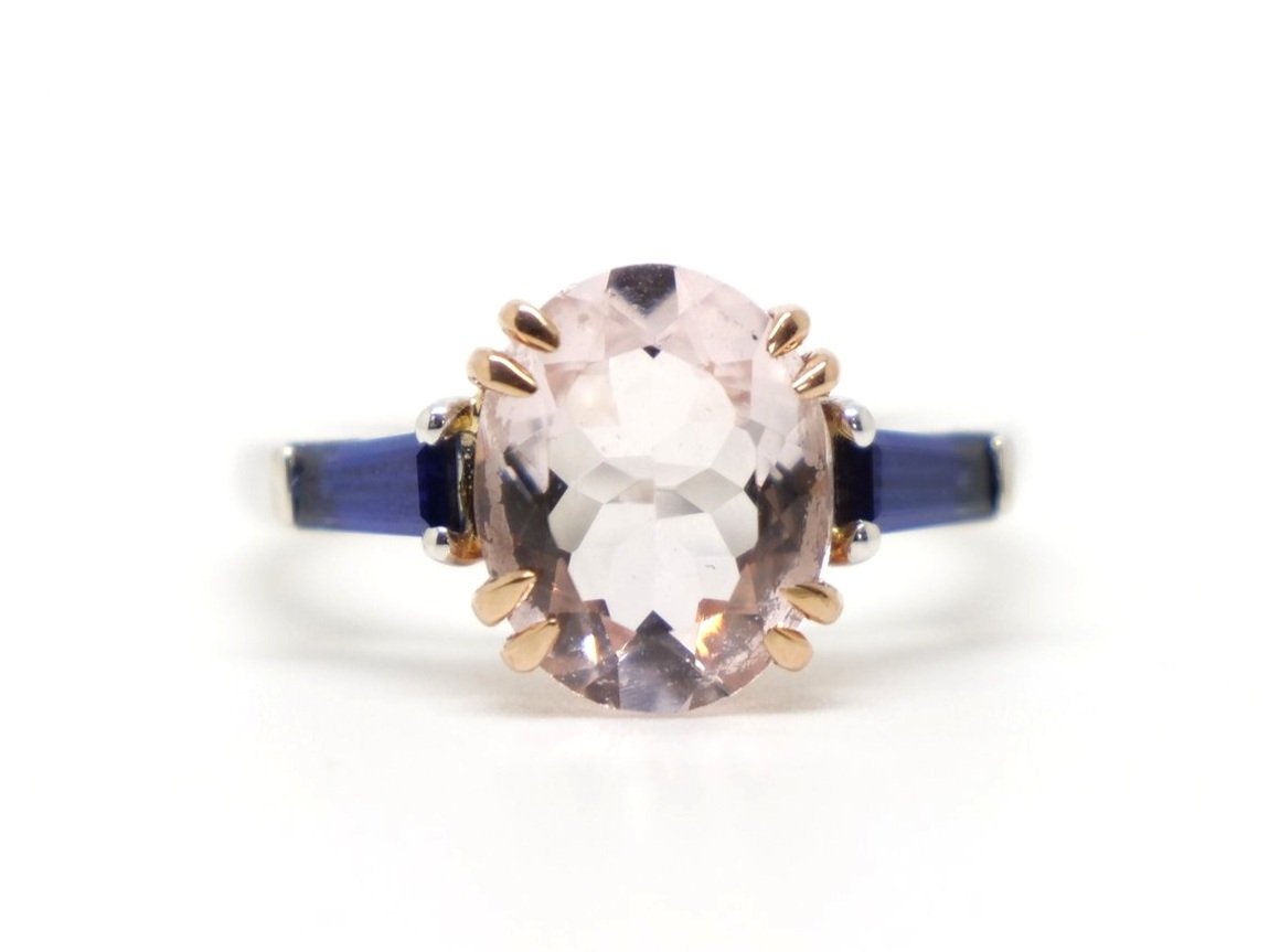 Stunning custom-made 18ct gold morganite and sapphire ring, set with a large oval cut morganite, with a tapered straight cut sapphire to each shoulder.