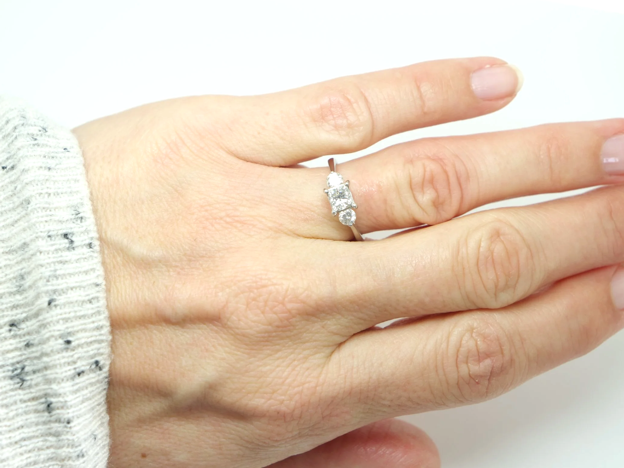 Super platinum diamond ring, set with a super princess cut centre diamond, with a brilliant cut diamond to each side.