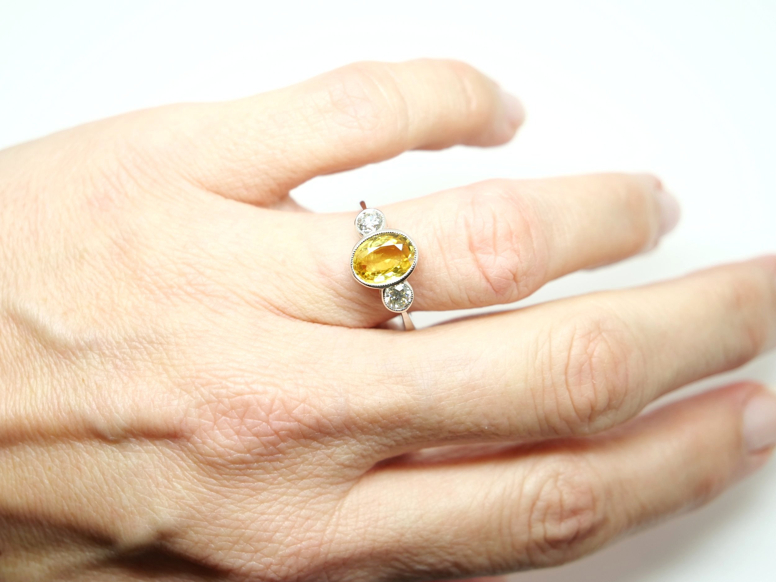 Superb classic design platinum oval cut yellow sapphire and diamond ring, set with a 2.25ct oval cut yellow sapphire with a brilliant cut diamond to each side.