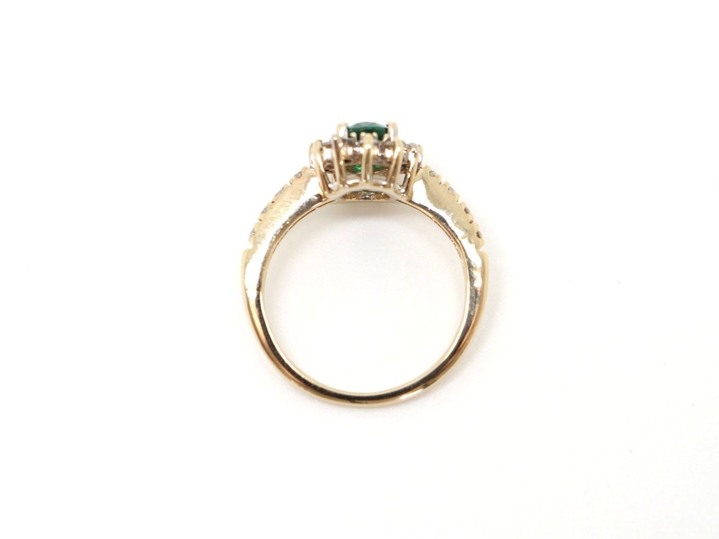 Super 14ct gold emerald and diamond cluster ring, set with a central oval cut emerald of approximately 0.75cts, surrounded by diamonds. With further brilliant cut diamonds set into each shoulder.
