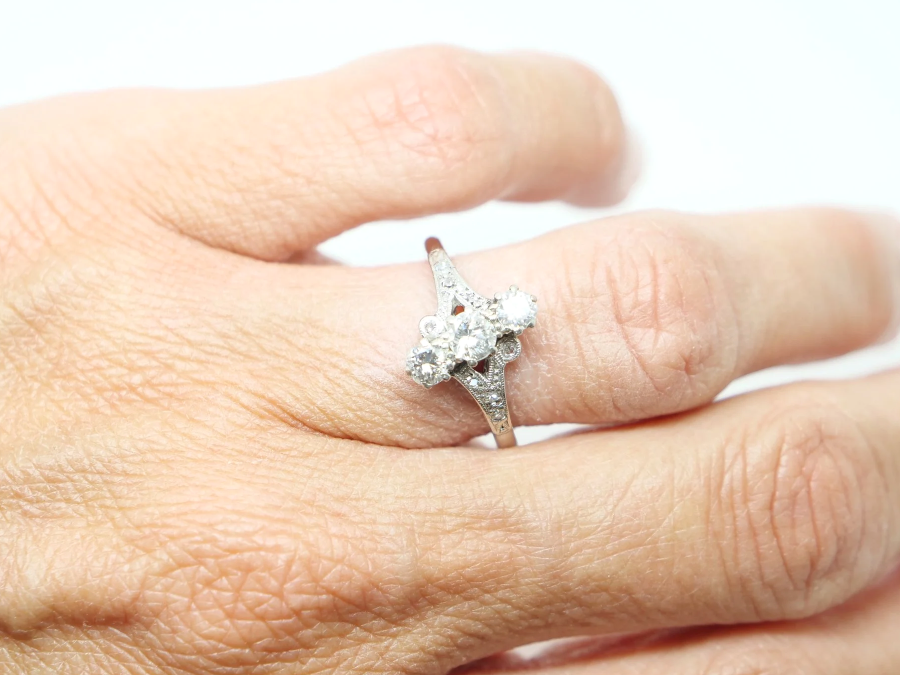 Beautiful platinum Art Deco ring, set with three central diamonds, with further small diamonds set into this unusual design.