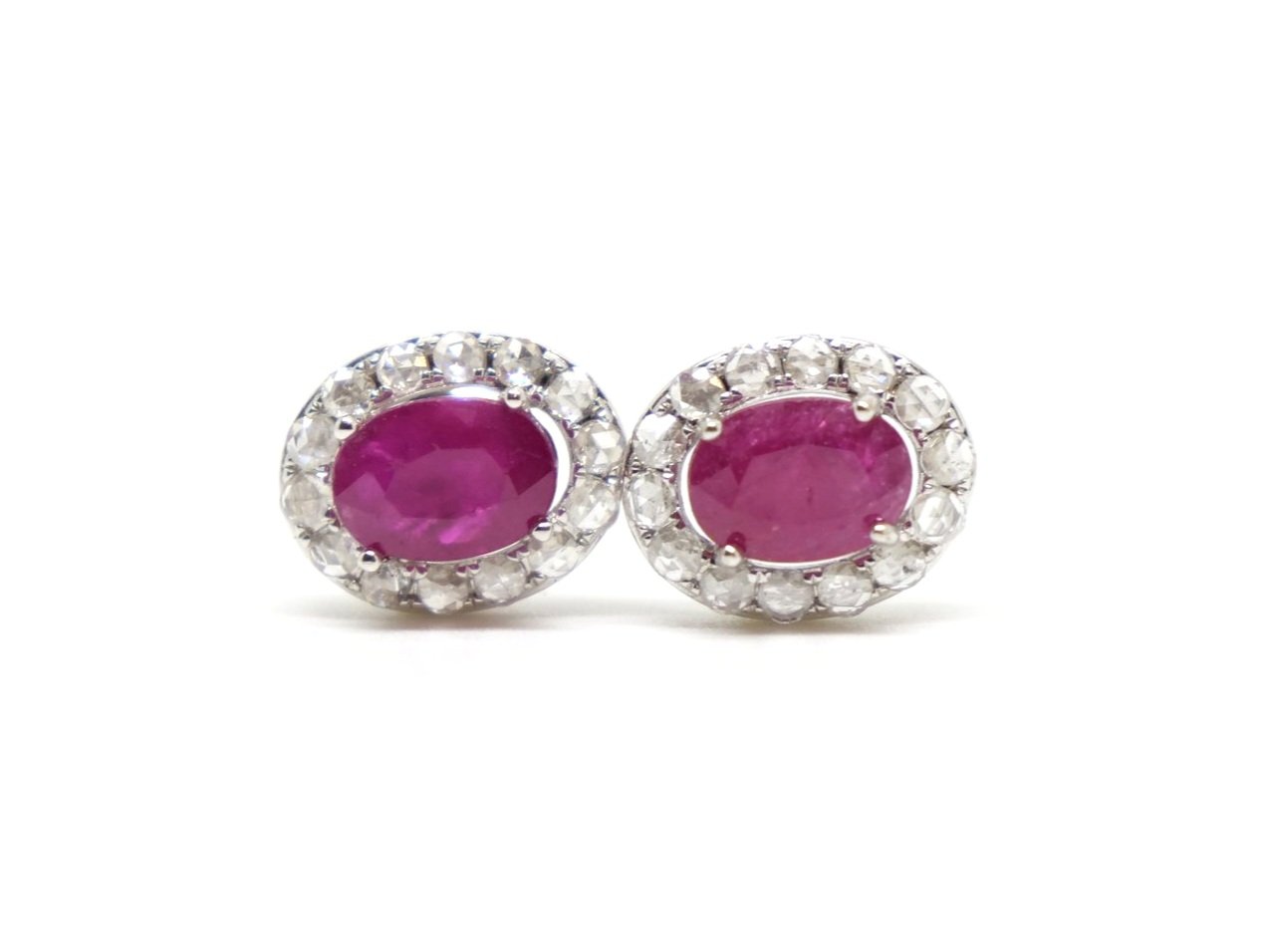 Lovely 18ct gold ruby and diamond earrings, each set with an oval cut ruby and surrounded by rose cut diamonds.