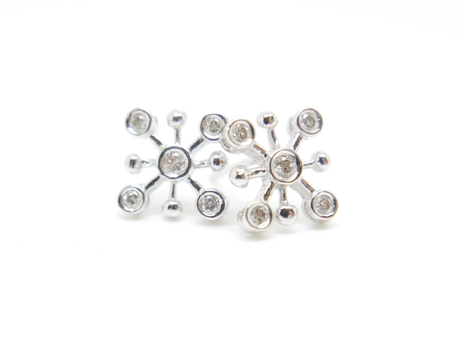 Very pretty diamond earrings in a contemporary snowflake design. Each earring has a central diamond, with four further diamonds. All in 18ct white gold.