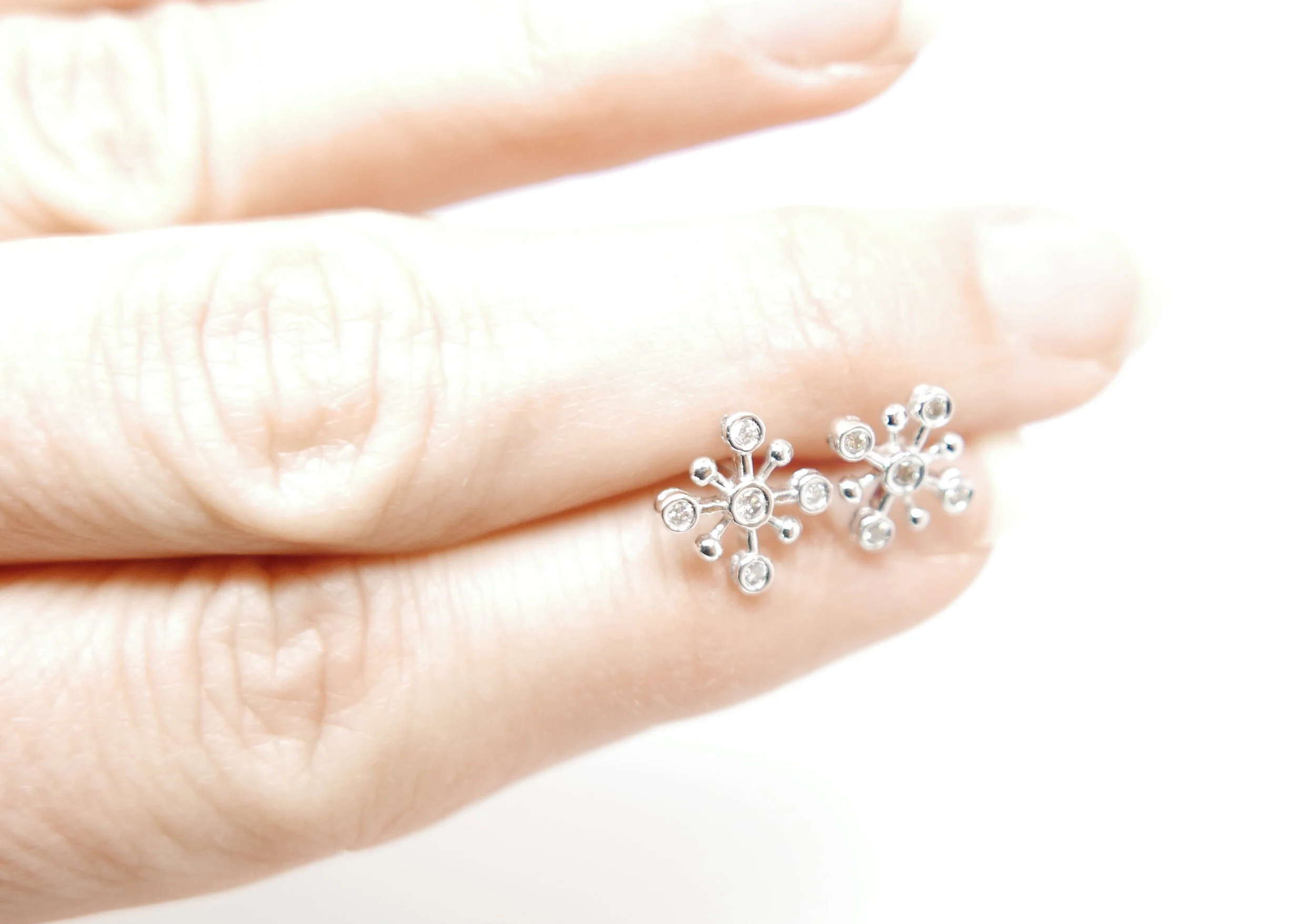 Very pretty diamond earrings in a contemporary snowflake design. Each earring has a central diamond, with four further diamonds. All in 18ct white gold.