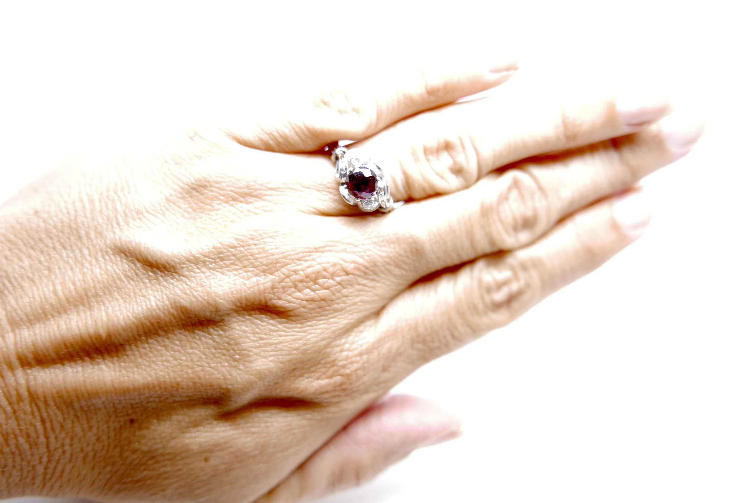 Beautiful Art Deco ring, set with a central round cut ruby, with a diamond to each side. Lovely unusual ribbon design to each shoulder. All set in 18ct white gold and platinum.