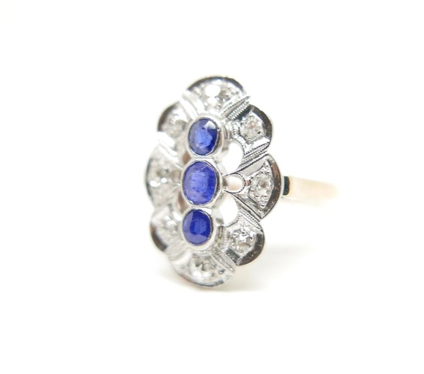 Art Deco Oval ring in platinum and 18ct white gold, set with three central sapphires and diamond surround. Pretty scalloped edges.