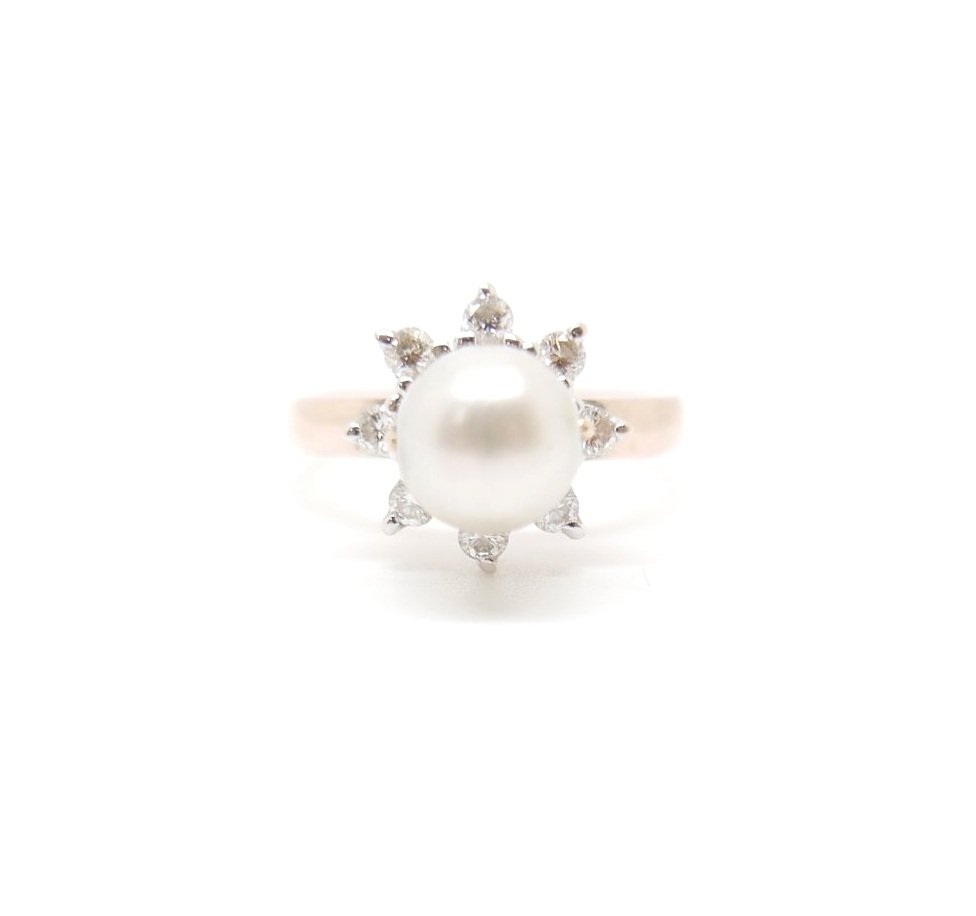 Vintage pearl and diamond ring set in 18ct gold. The central pearl is surrounded by eight brilliant cut diamonds, with the pearl able to rotate. The band is 18ct yellow gold.