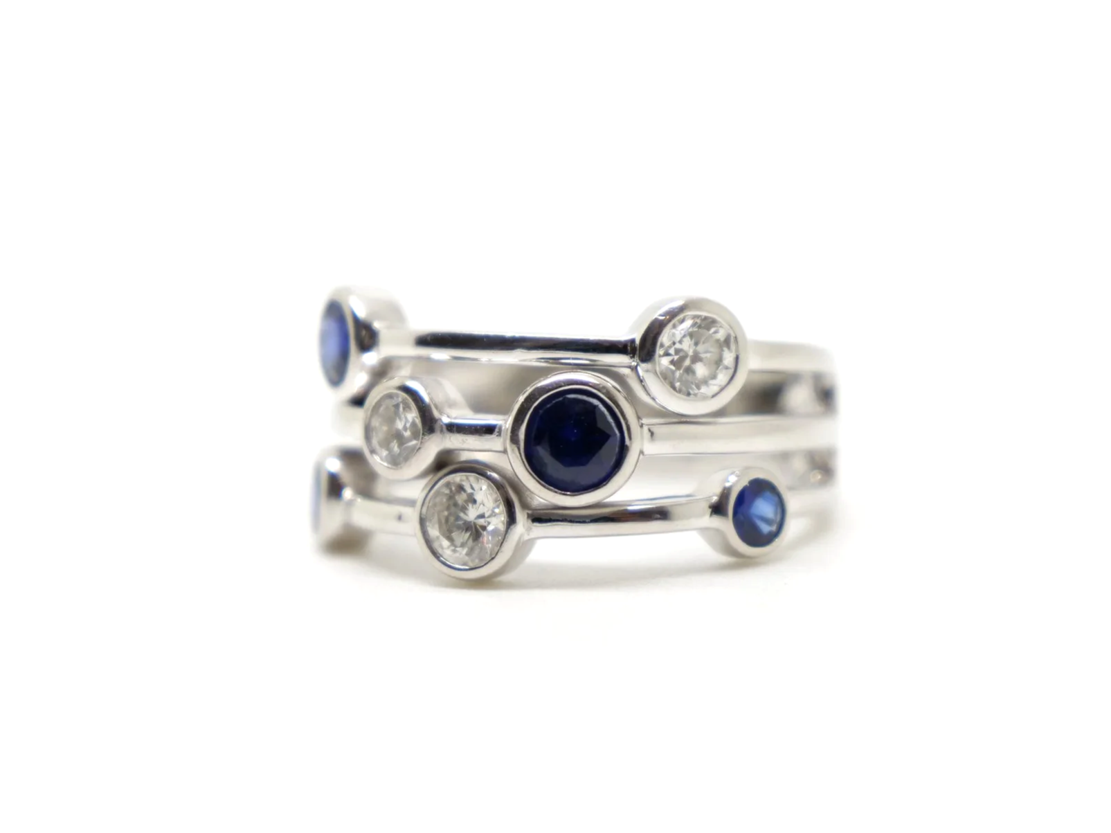 Beautiful platinum sapphire and diamond ring, often called a bubble ring and designed in the style of Boodles Raindance collection. Set with four sapphires and three diamonds.