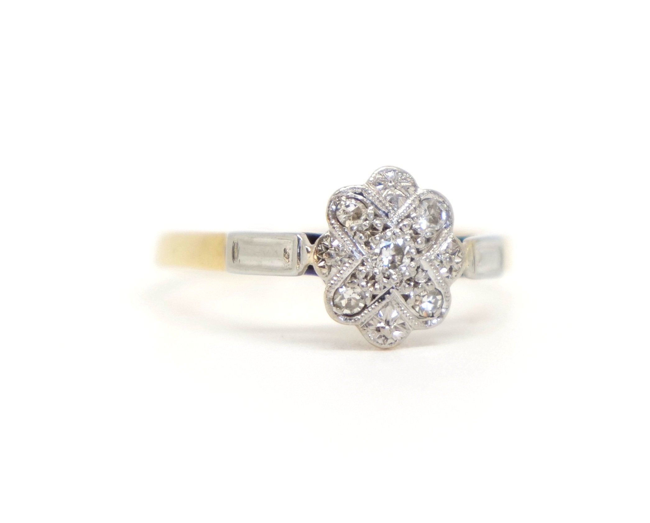 Art Deco ring in a flower and cross design, set with five small diamonds. Set in platinum, with platinum to each shoulder. The rest of the ring is 18ct gold.