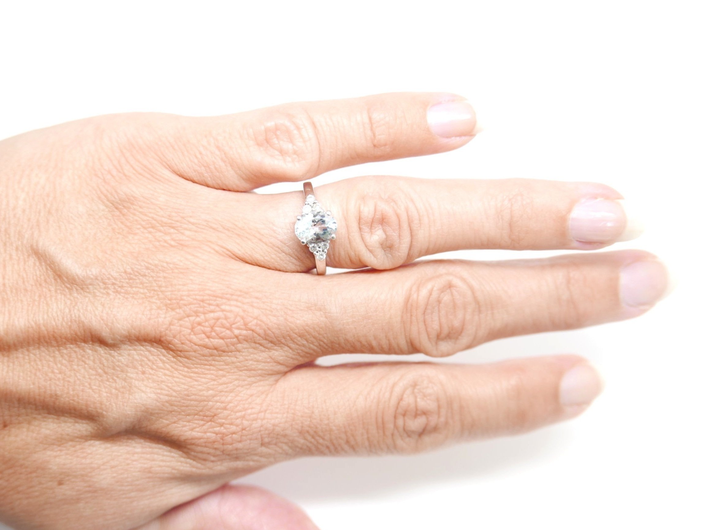 Classic and elegant oval cut aquamarine and diamond ring, set with a central oval cut aquamarine of approximately 1.1cts. There are trefoil diamonds to each side. Set in 9ct white gold.