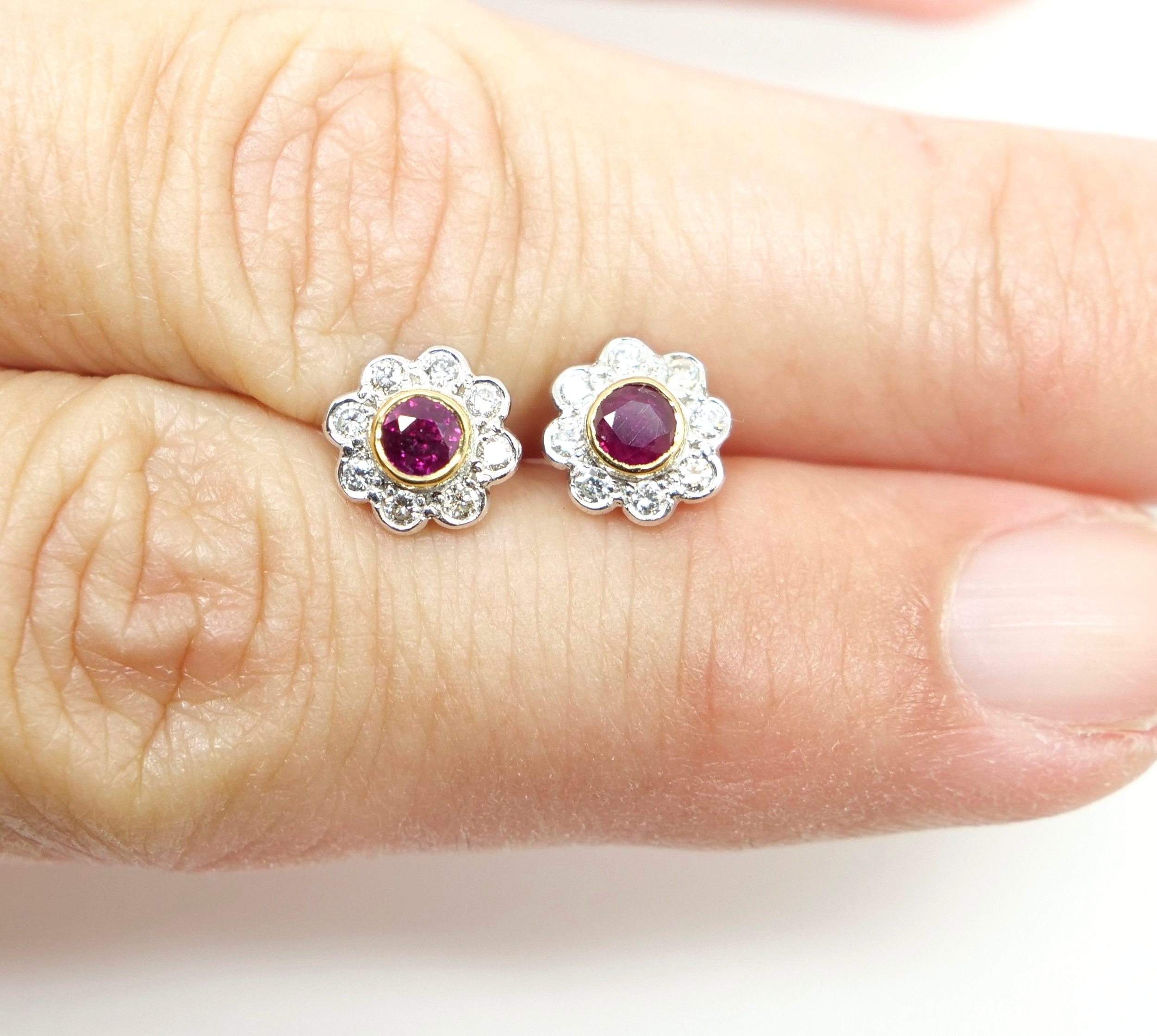 Lovely ruby and diamond flower earrings, set in 18ct gold. Central round cut rubies, surrounded by brilliant cut diamonds. With 18ct gold butterfly backs.