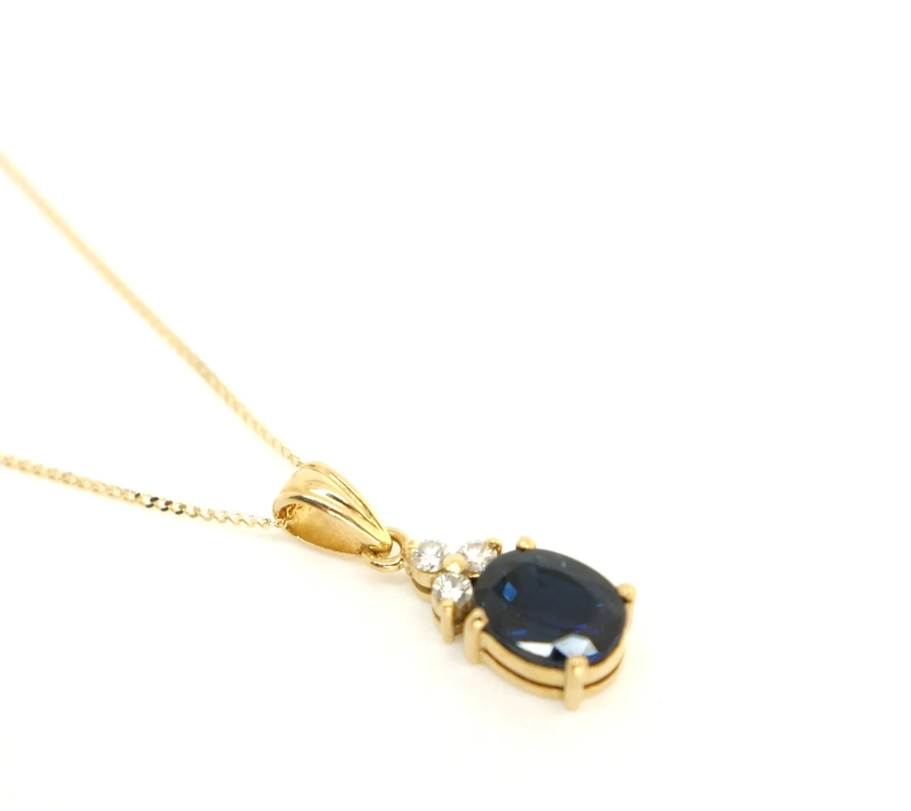 Classic sapphire and diamond pendant, set with a central oval cut sapphire and three brilliant cut diamonds above. All set in 18ct gold, with 16” 18ct gold chain.