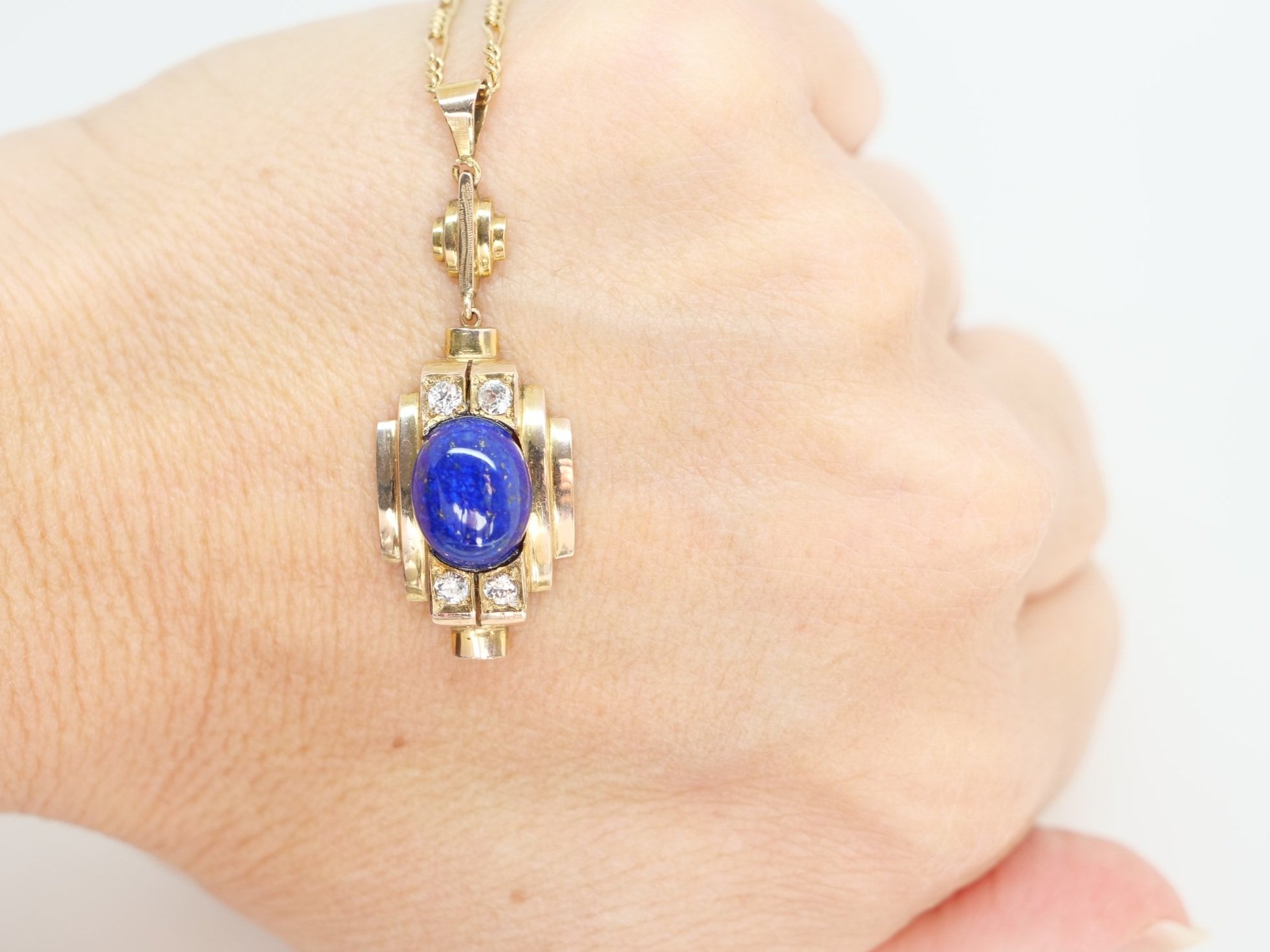 Very unusual vintage pendant, set with a large central lapis lazuli stone, with four white sapphires. Lovely Art Deco design in 14ct gold, with 9ct gold chain.
