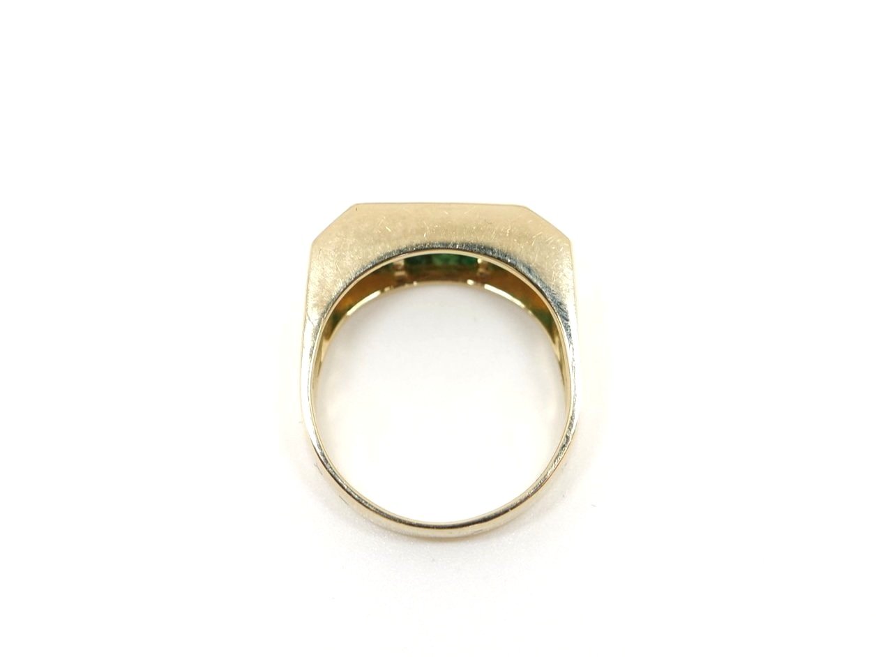 Very unusual diamond and emerald ring, set with a central row of brilliant cut diamonds, with a row of step cut emeralds both above and below. Set in heavy 14ct gold.