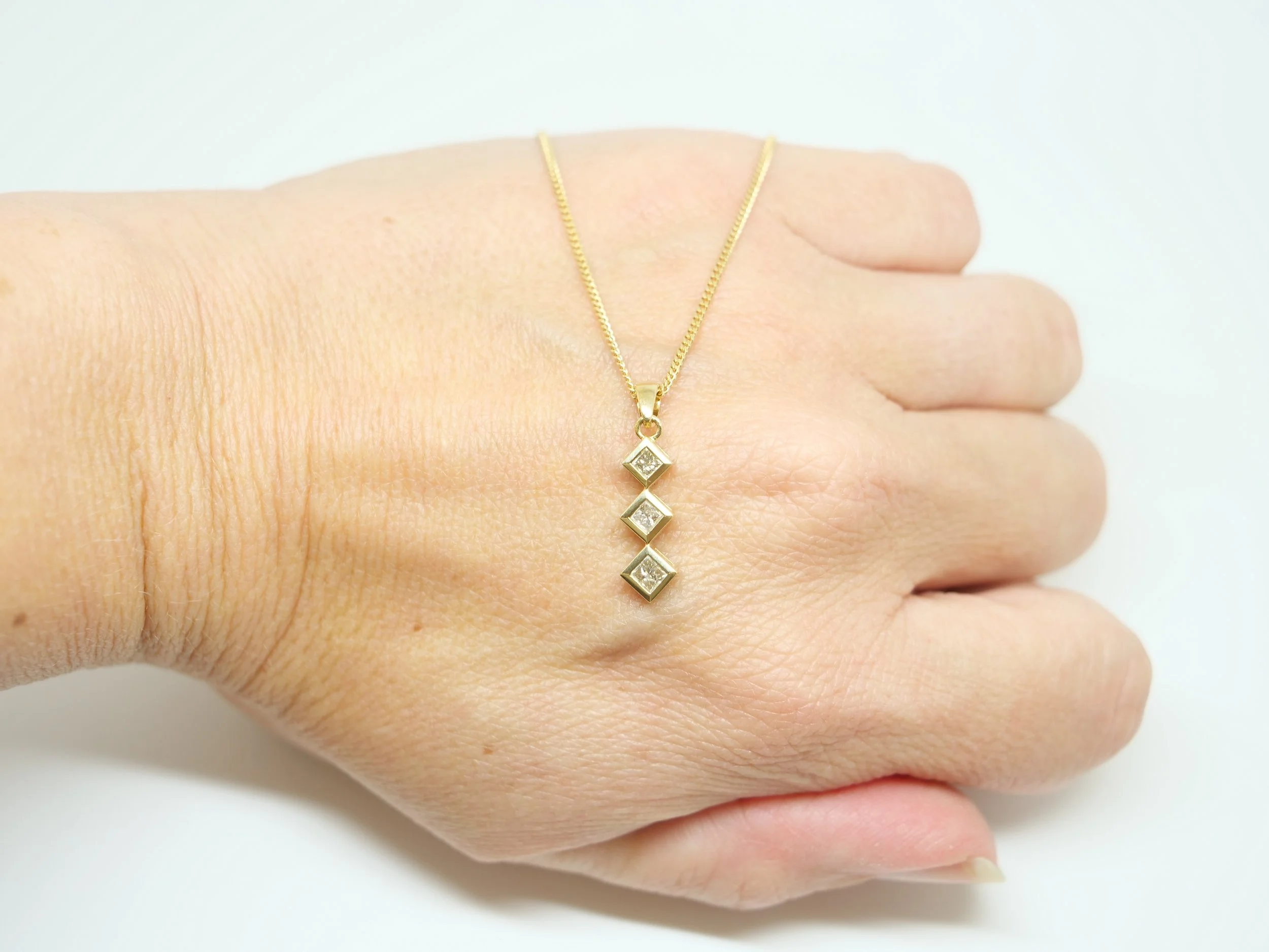 Vintage pendant and chain, set with three princess cut diamonds in this pretty drop design. All set in 18ct, with 18 inch 18ct gold chain.