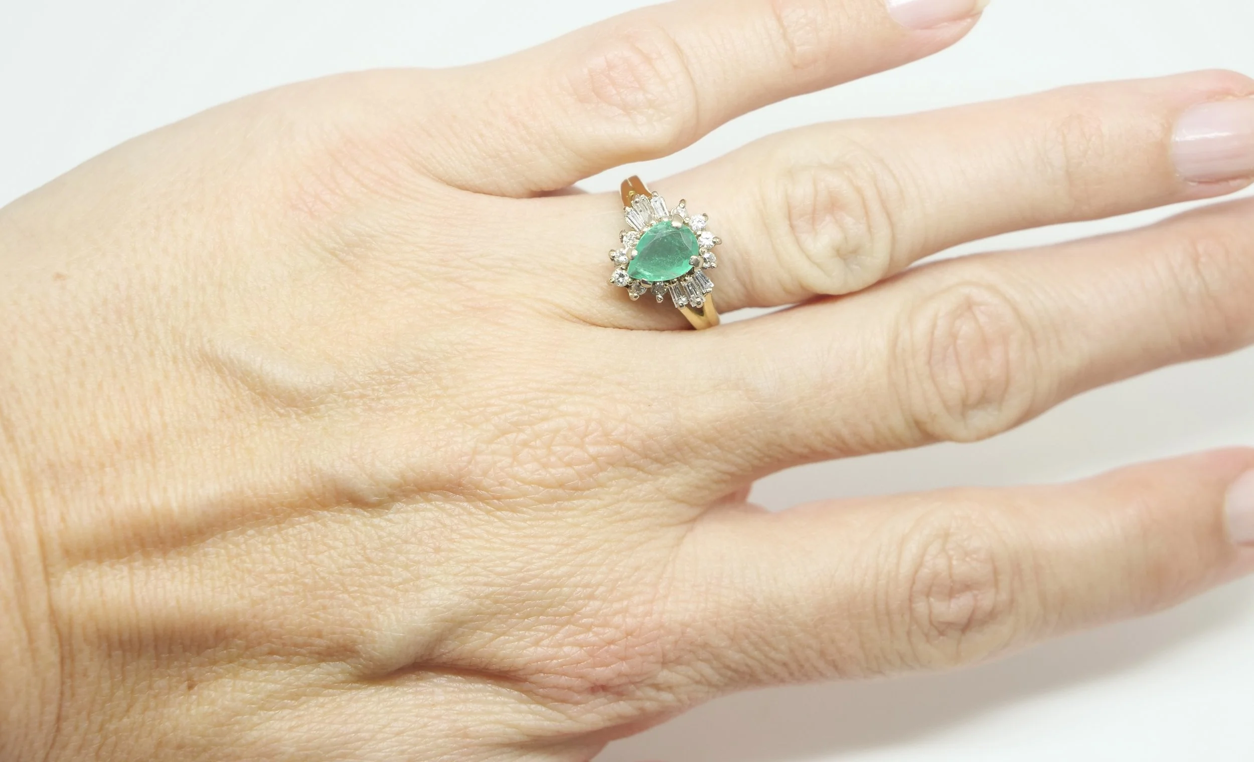Super vintage emerald and diamond ring, set with a central pear cut emerald, with baguette and brilliant cut diamonds in a ballerina setting. All in 18ct gold.