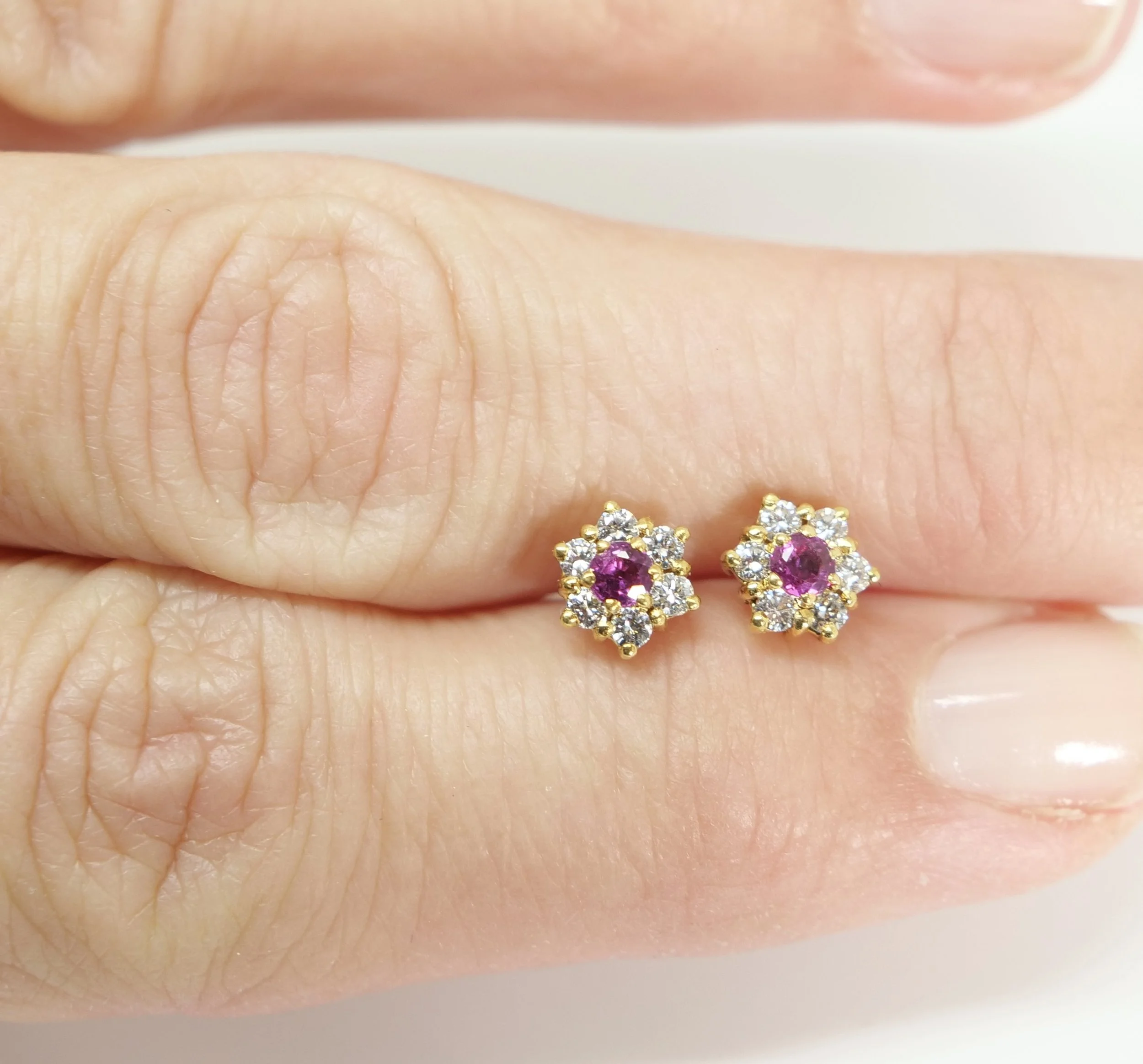 Lovely ruby and diamond flower stud earrings, set in 18ct gold. Central round cut ruby, surrounded by six brilliant cut diamonds.